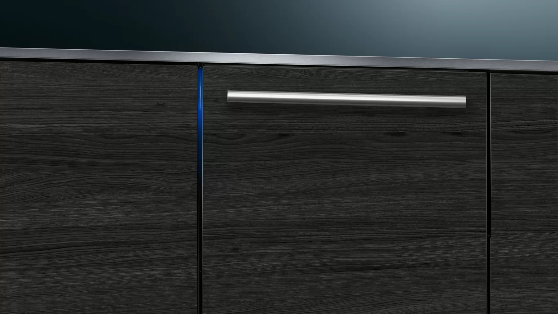 Primer plano de un armario de madera con un tirador plateado. Textura de vetas de madera oscura. Diseño minimalista.