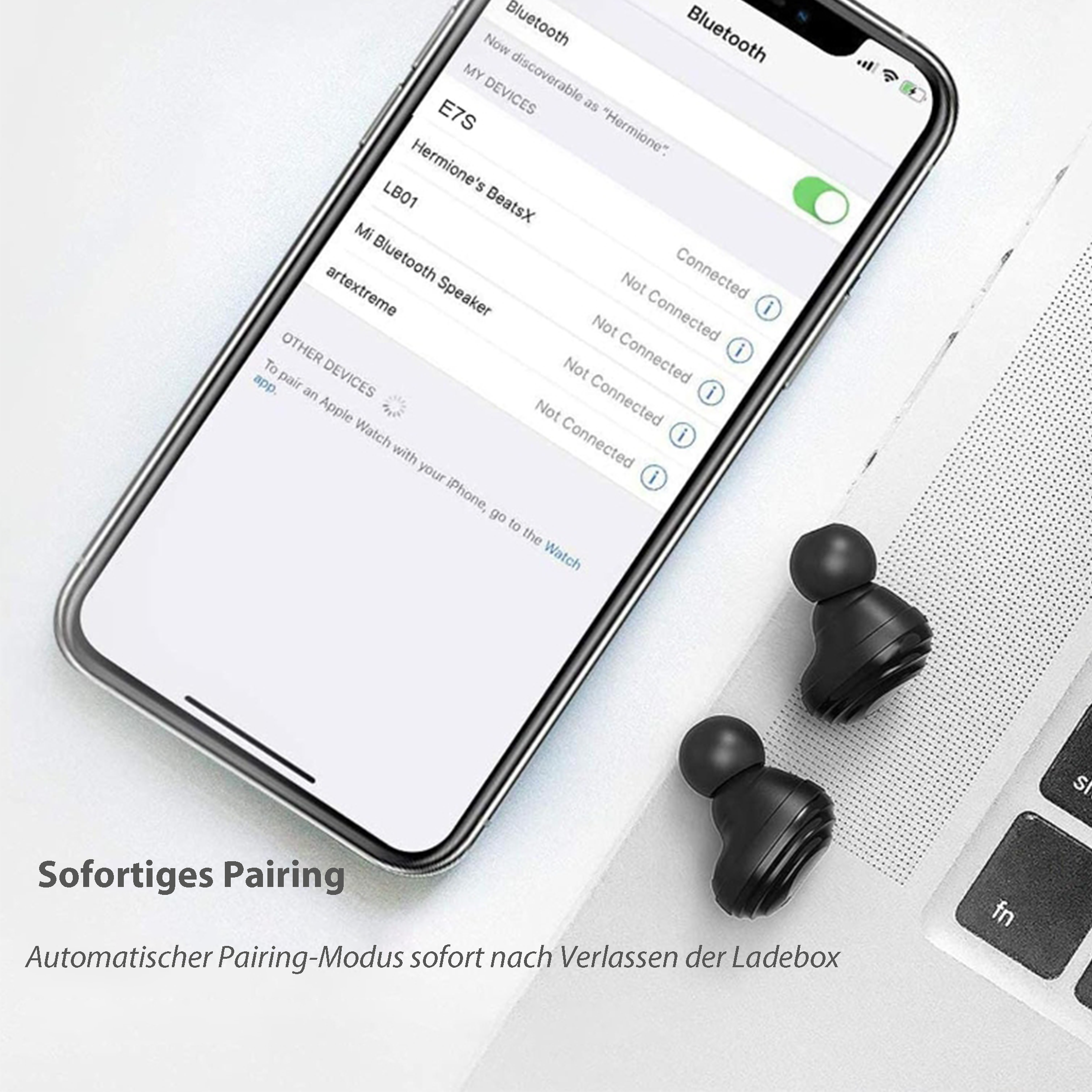 Paar schwarze kabellose Ohrhörer neben einem Telefon mit Bluetooth-Einstellungsbildschirm.