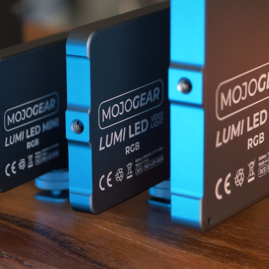 Three black Lumi LED video lights with blue accents. 'MOJOGEAR' and other text are visible.