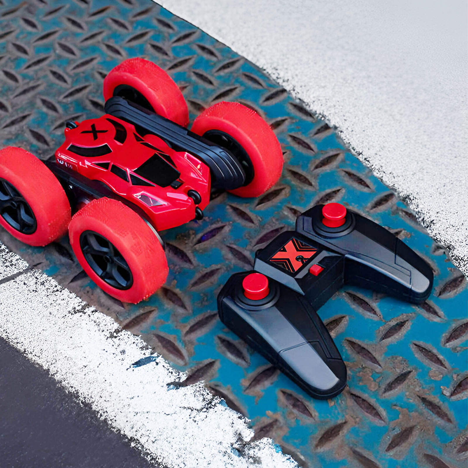 Ein rotes und schwarzes Spielzeugauto mit großen roten Rädern und zwei Fernbedienungen.