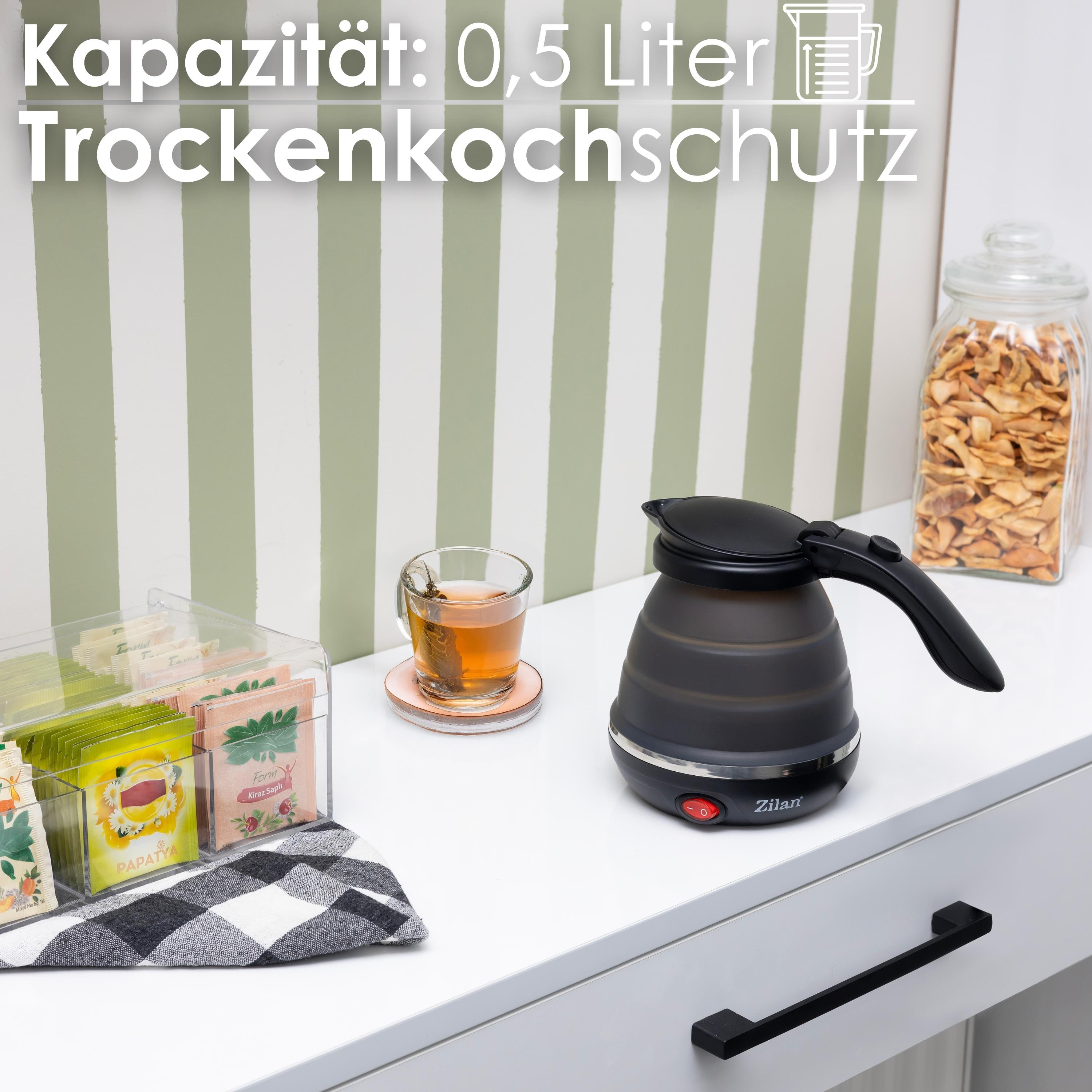 Schwarzer Wasserkocher mit Teebeuteln, ein Glas Tee und ein Glas Trockenfrüchte. Der Kocher ist faltbar.