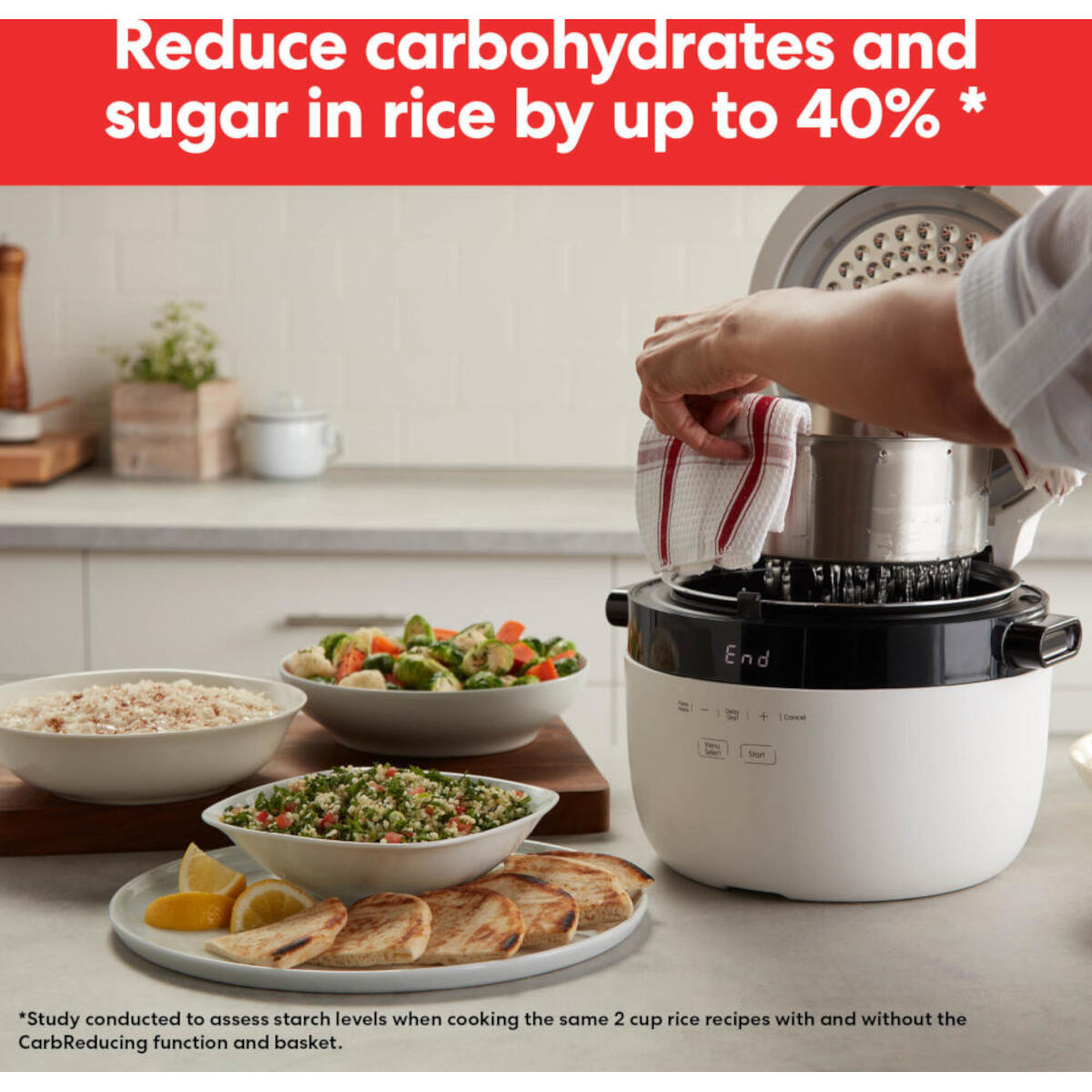 A woman operates a rice cooker with food bowls. Dishes of rice, veggies, and pita bread are visible.