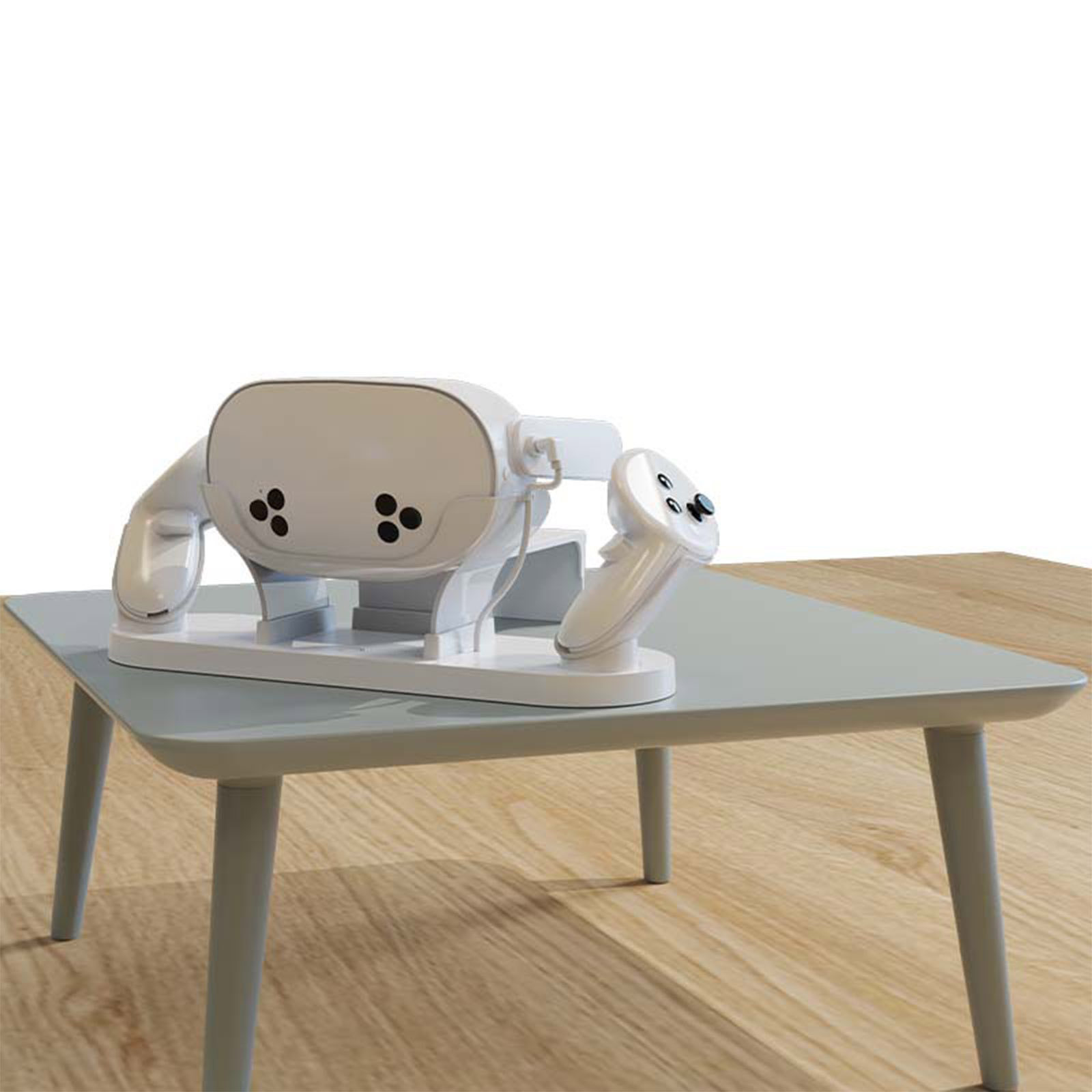 Weißes VR-Headset und Controller auf einem hellgrauen Tisch. Holzboden im Hintergrund.