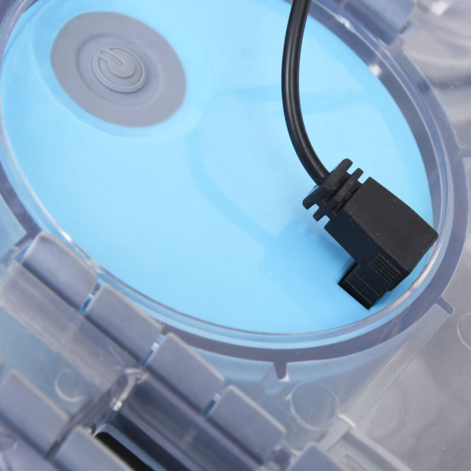 Nahaufnahme eines hellblauen Kreises mit einem schwarzen Kabel, das eingesteckt ist.