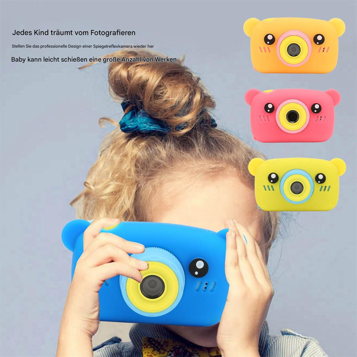 Ein Kind hält eine blaue Spielzeugkamera. Drei Spielzeugkameras in verschiedenen Farben sind sichtbar.
