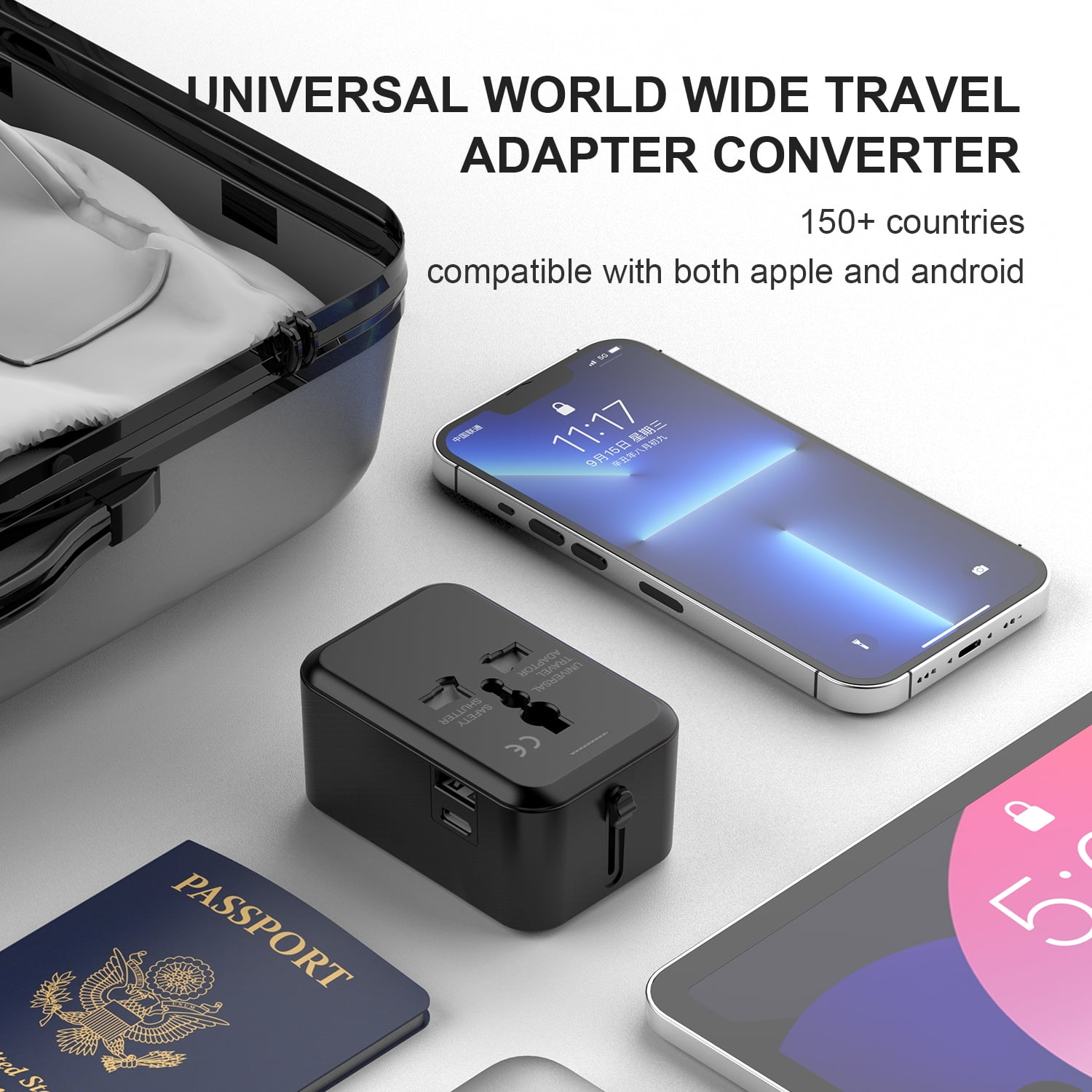 Schwarzer Reiseadapter neben einem Reisepass, Telefon und Tablet. Er ist universal.