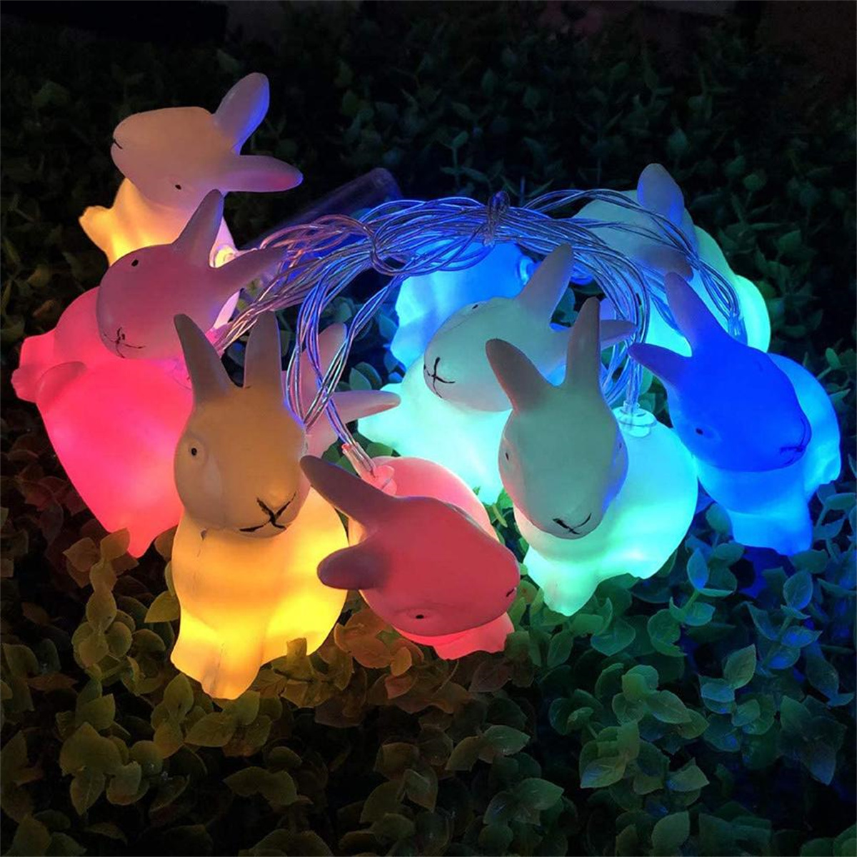 Lichterkette mit hasenförmigen Lichtern in verschiedenen Farben. Beleuchtet in dunkler Umgebung.