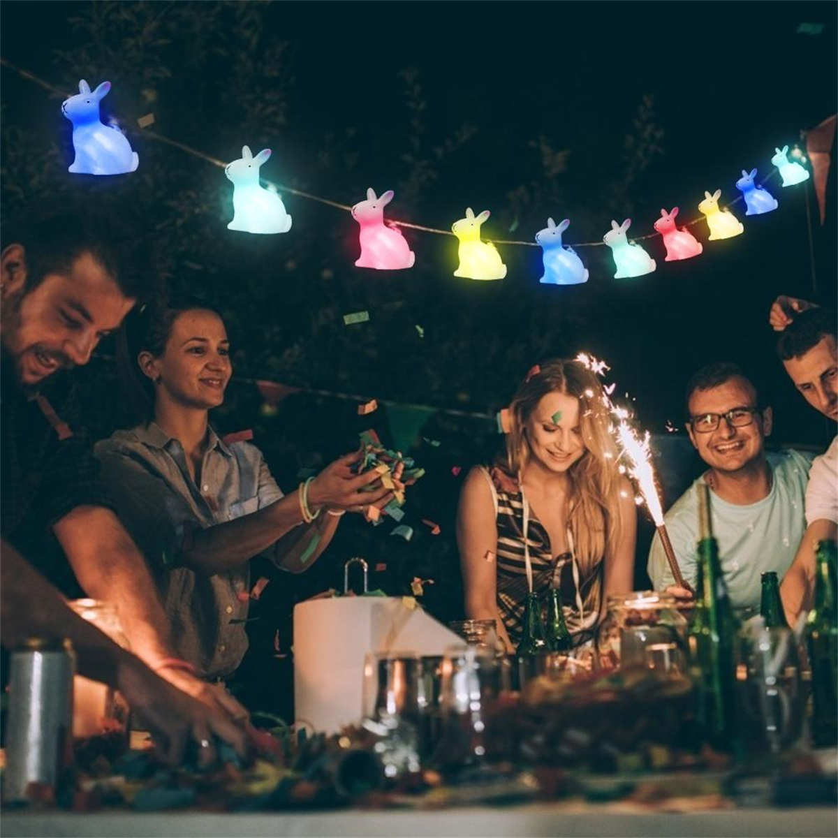Leute auf einer Party mit Lichterketten in Hasenform. Text im Bild.