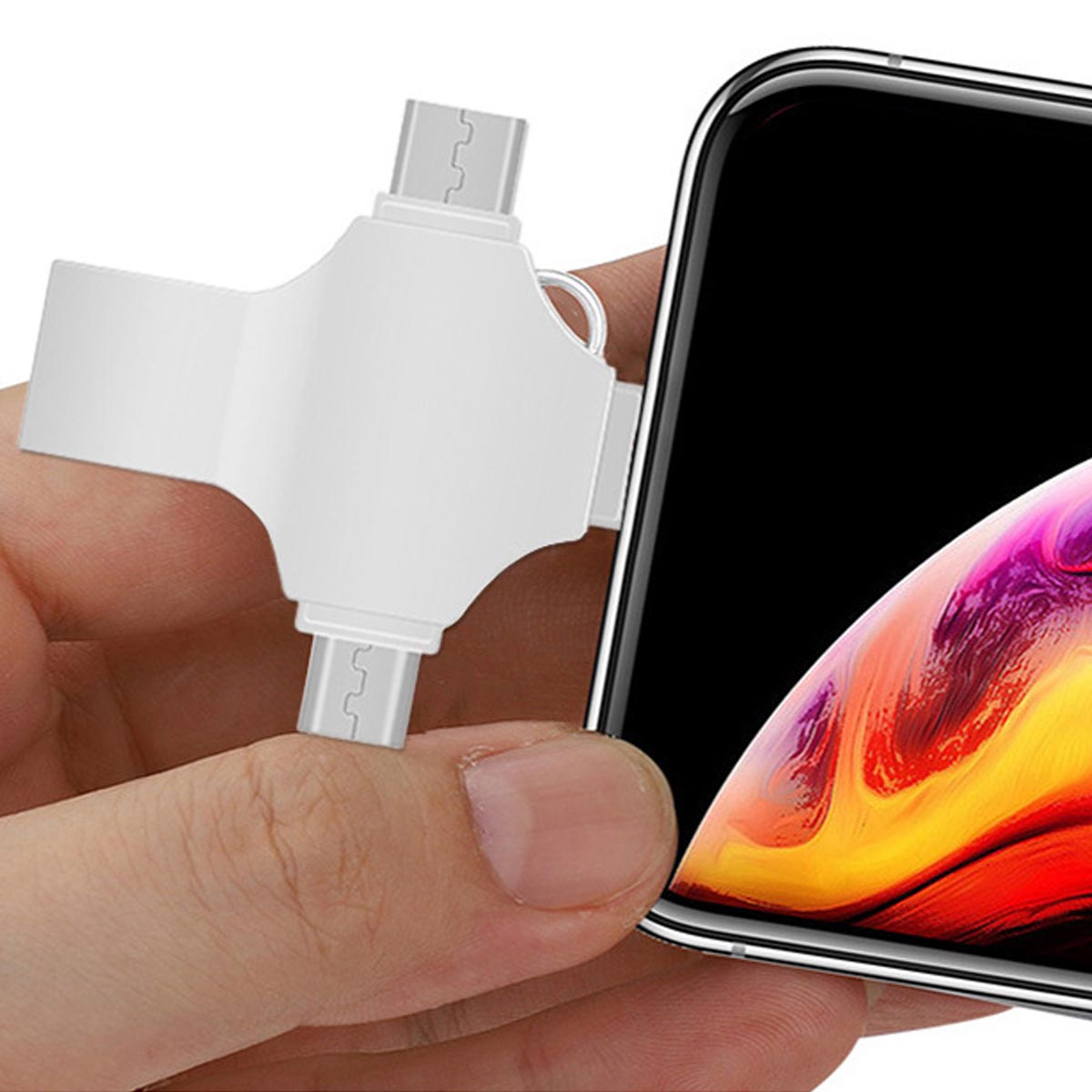 Hand hält weißen Multi-Anschluss für Telefon, Telefon im Blick. Telefon hat schwarzen Bildschirm.