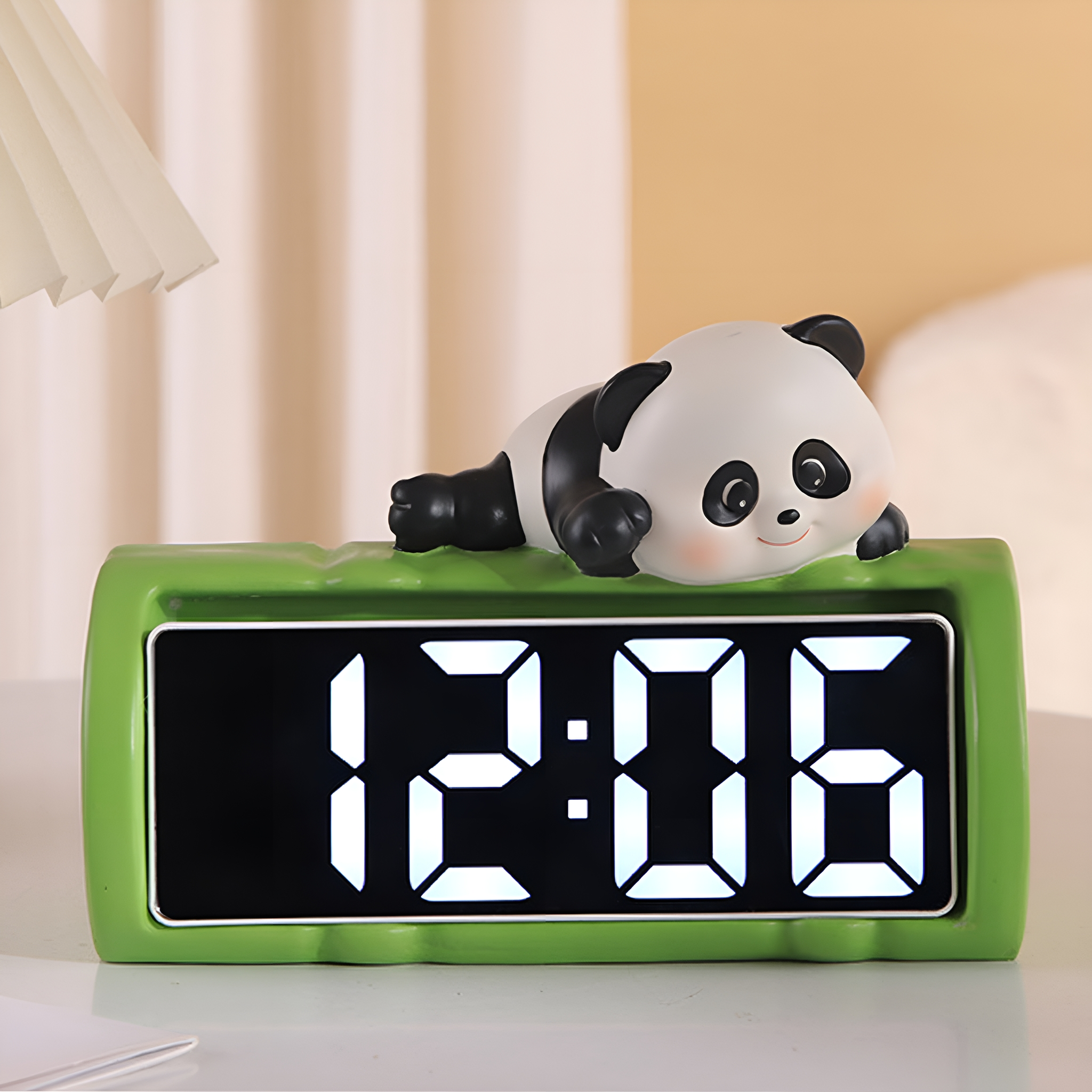 Grüner Wecker mit Panda oben, zeigt 12:06 an.