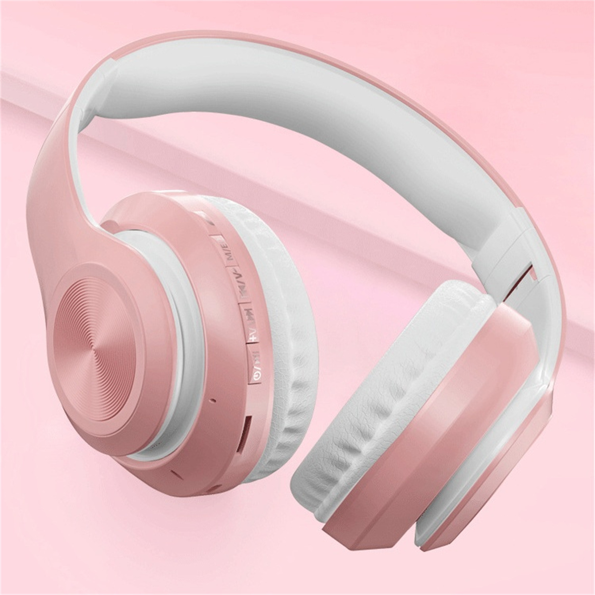 Rosa-weiße Over-Ear-Kopfhörer vor rosa Hintergrund.