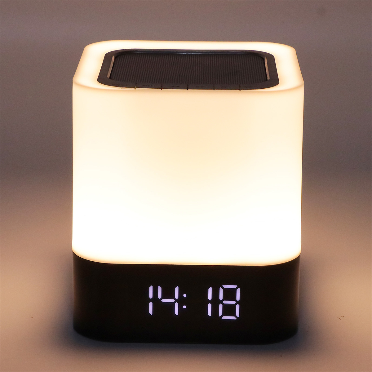Weiß-schwarze Nachttischlampe mit LED-Anzeige 14:18, auf warmem Hintergrund.