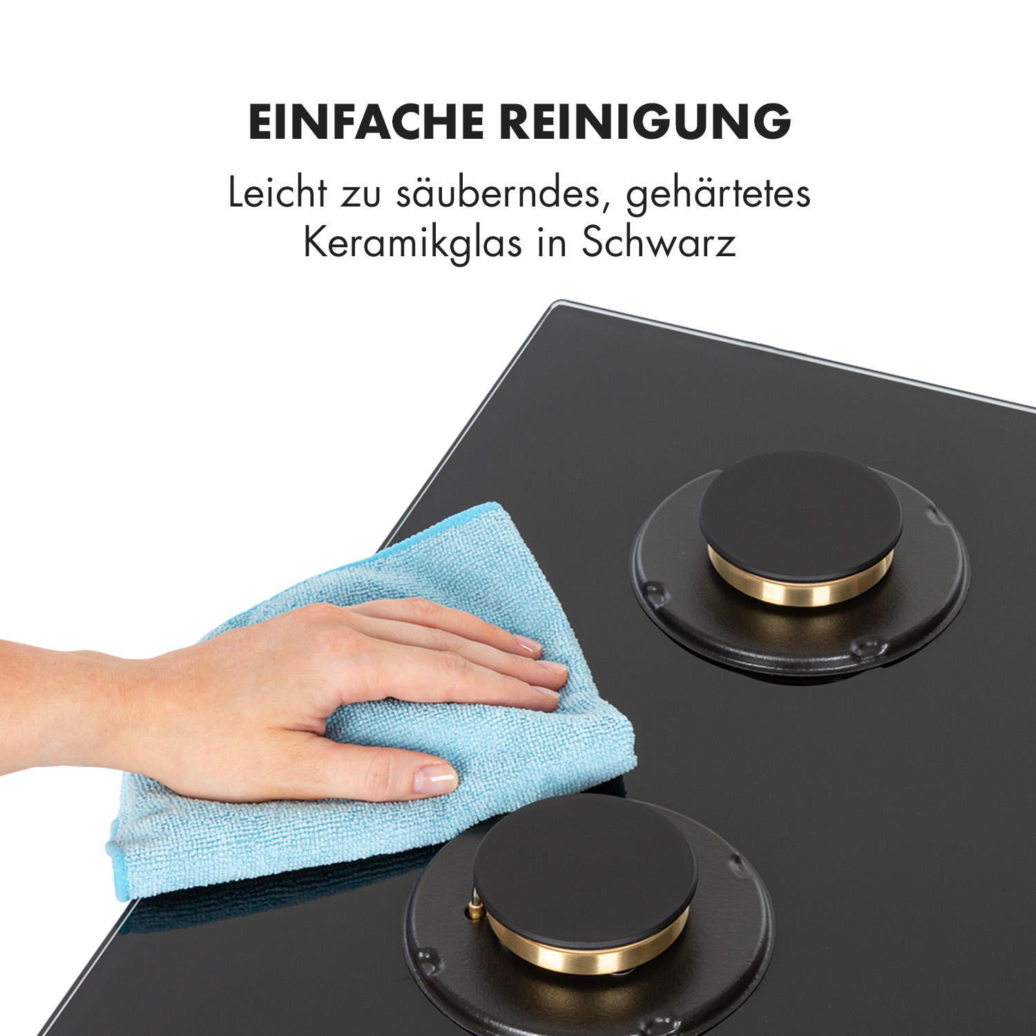 Eine Hand wischt ein blaues Tuch über ein schwarzes Kochfeld mit zwei Brennern ab.