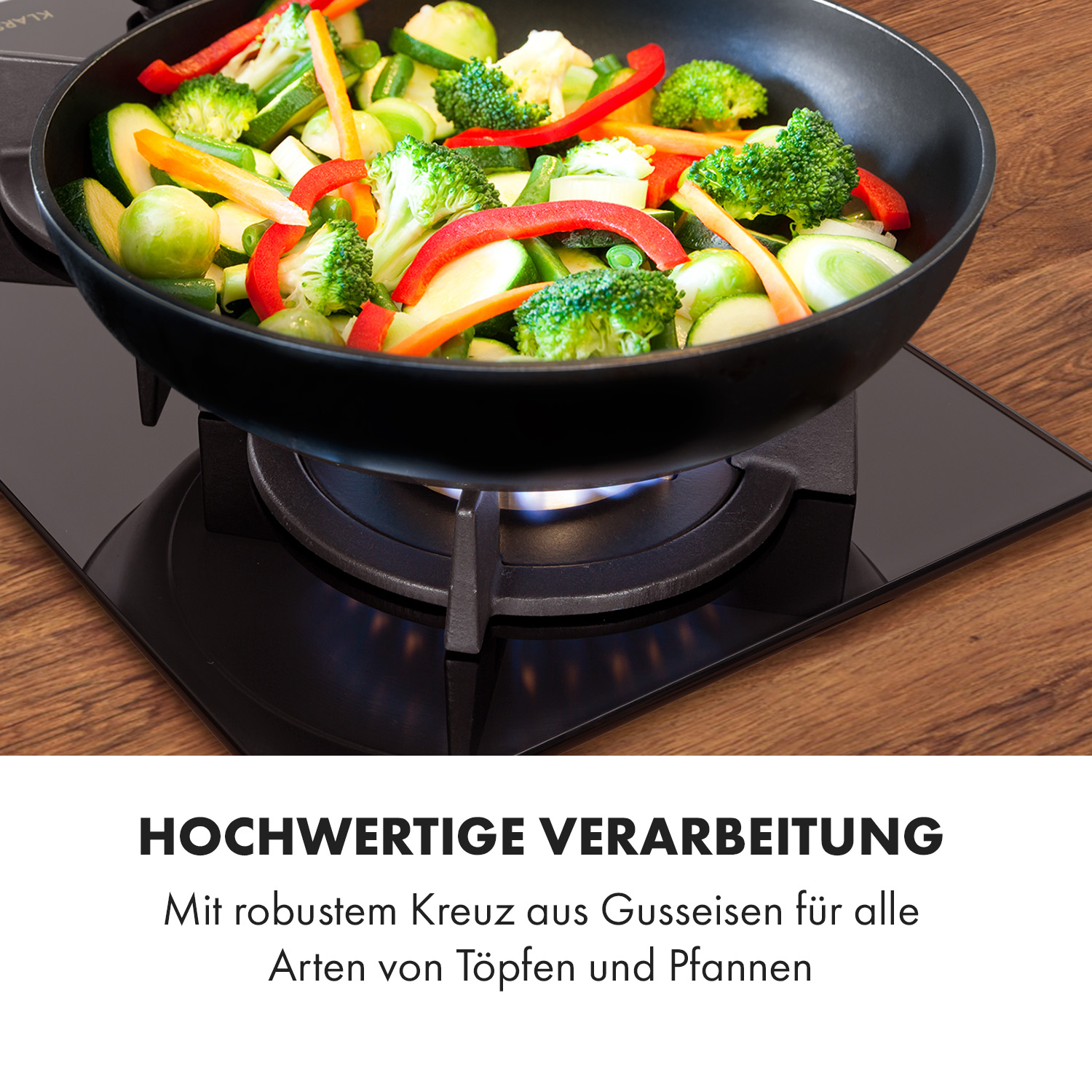 Bratpfanne auf einem Herd mit Gemüse, das kocht. Der Herd hat eine schwarze Oberfläche.