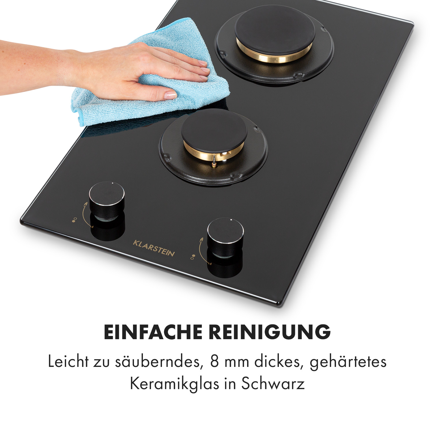Schwarzes Kochfeld mit zwei Brennern und Knöpfen. Hand wischt die Oberfläche.