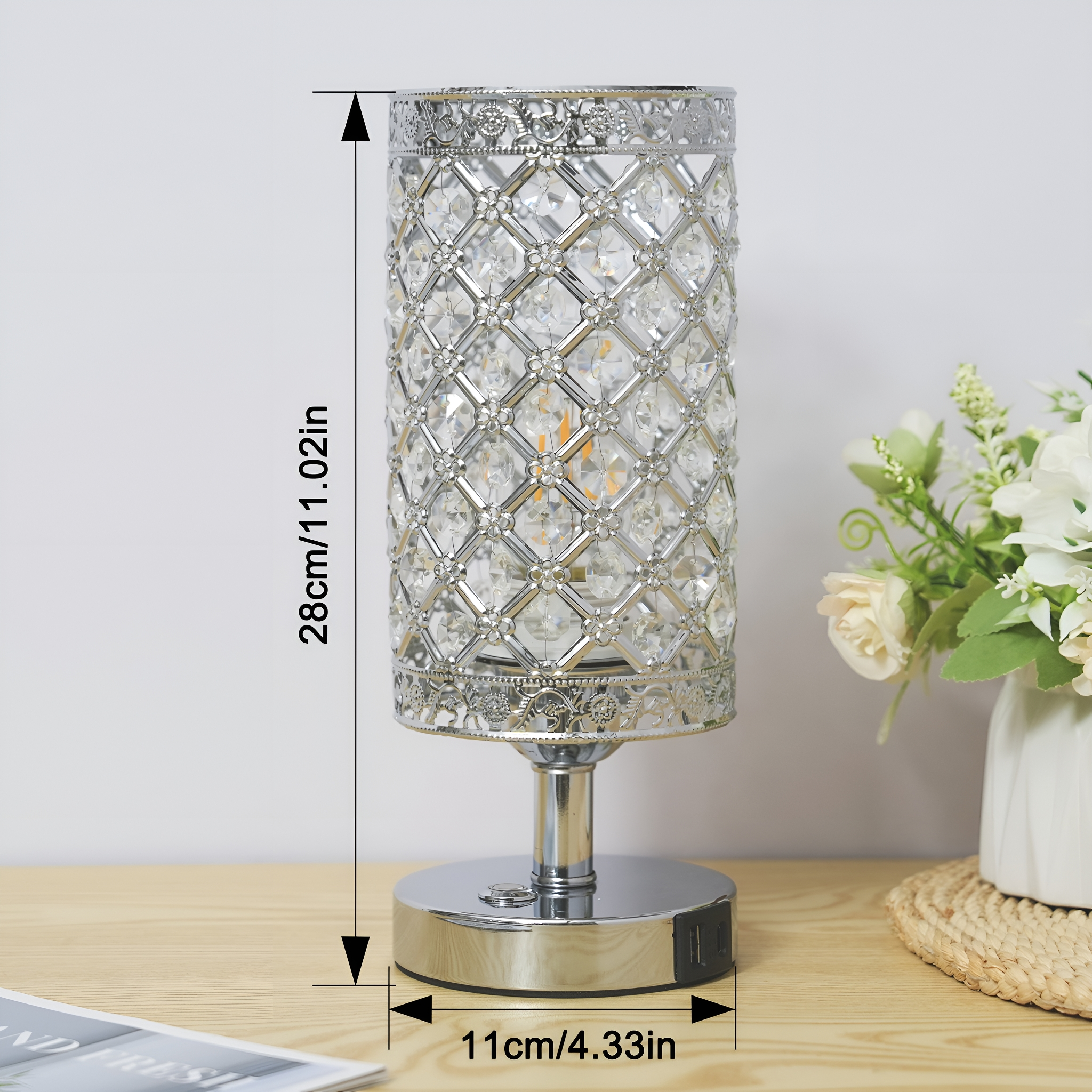Silberne Kristall-Tischlampe mit zylindrischem Schirm und rundem Fuß auf Holztisch.