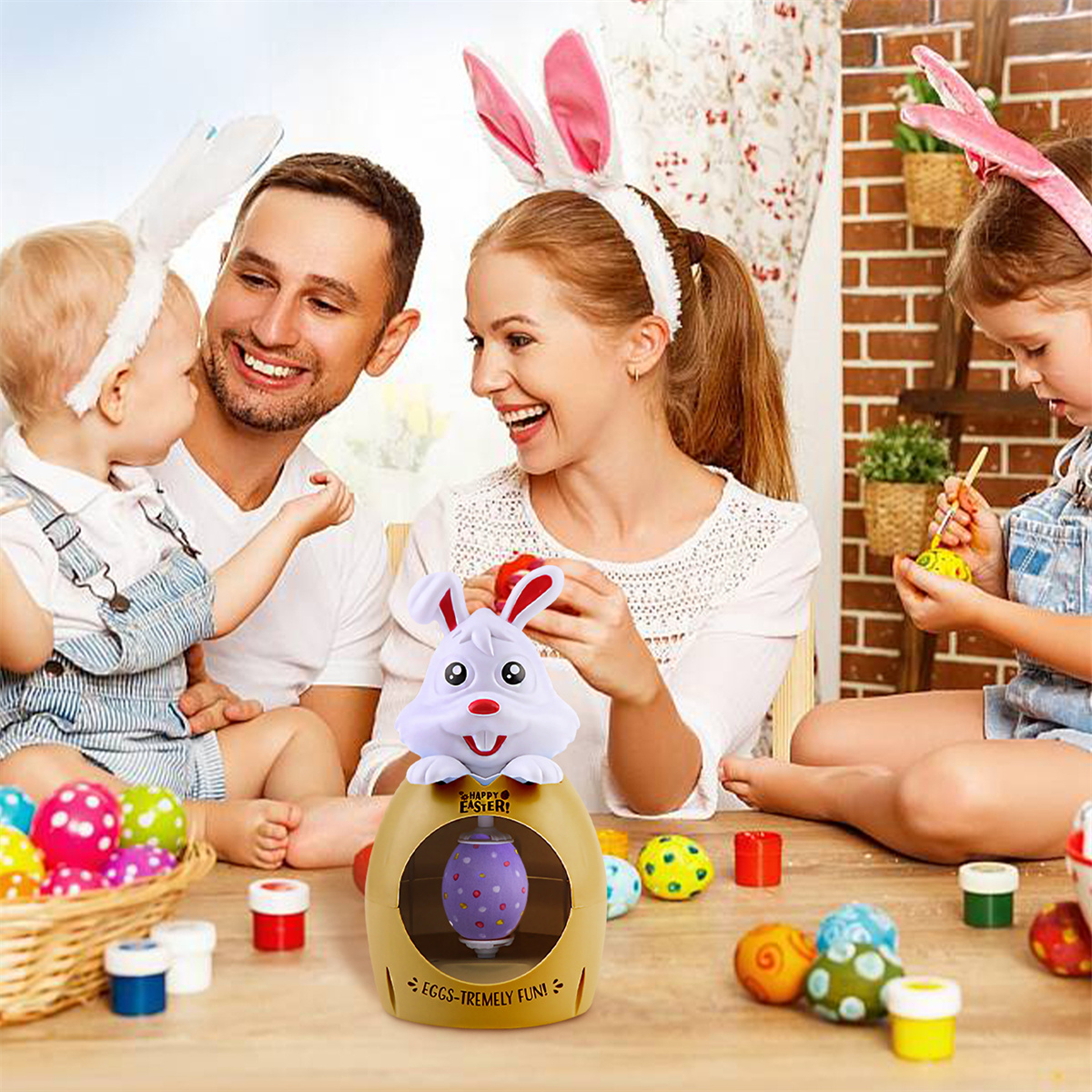 Familie an Ostern: Eltern und Kinder mit Hasenohren, Eier dekorieren und Spielzeug-Hase.