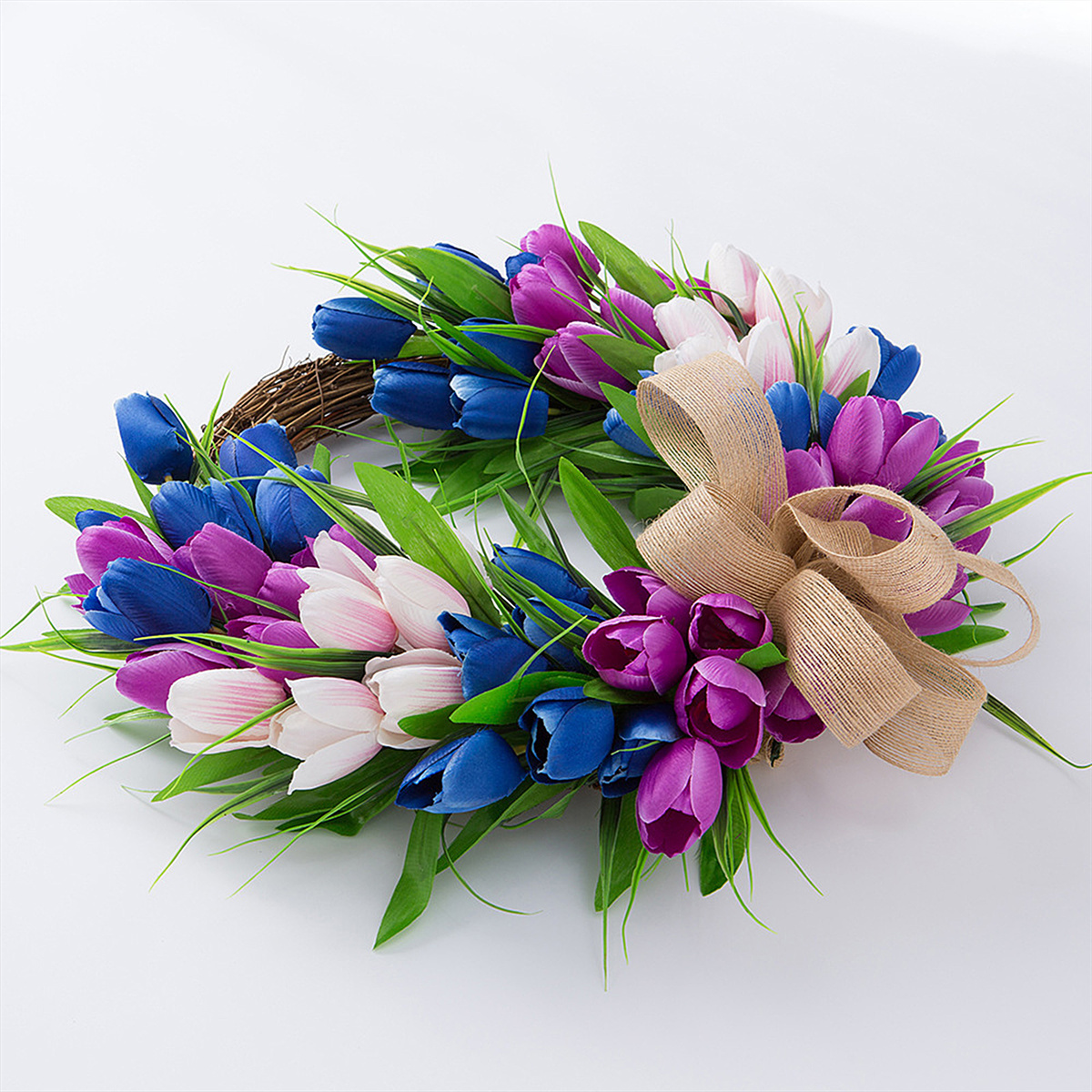 Kranz aus bunten Tulpen mit einem Schleife aus Jute, vor weißem Hintergrund.