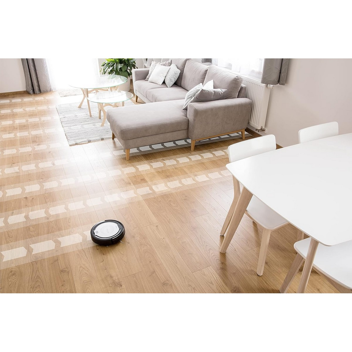 Un aspirateur robot nettoyant un sol en bois. Des flèches indiquent le trajet de nettoyage.