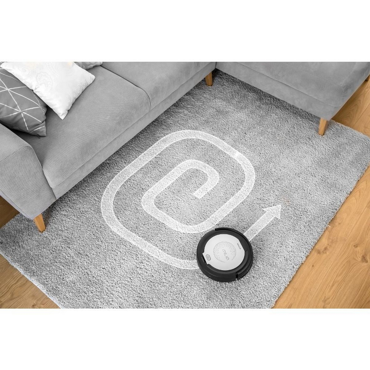 Aspirateur robot sur un tapis gris, avec un chemin de nettoyage en spirale blanc.