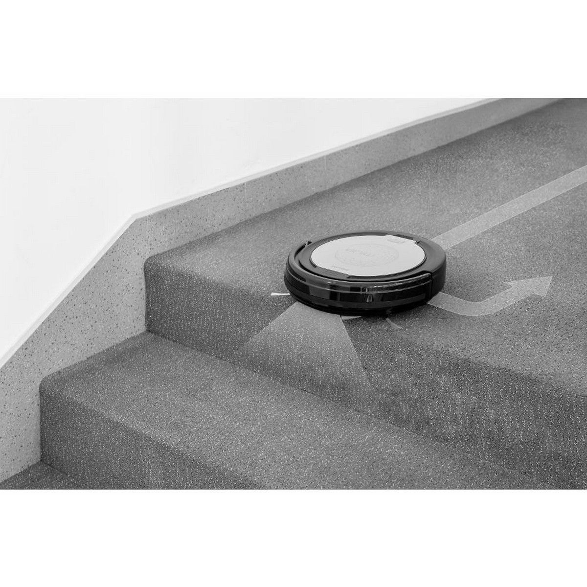 Aspirateur robot sur des escaliers. Noir et gris. Flèche indique le chemin de nettoyage.