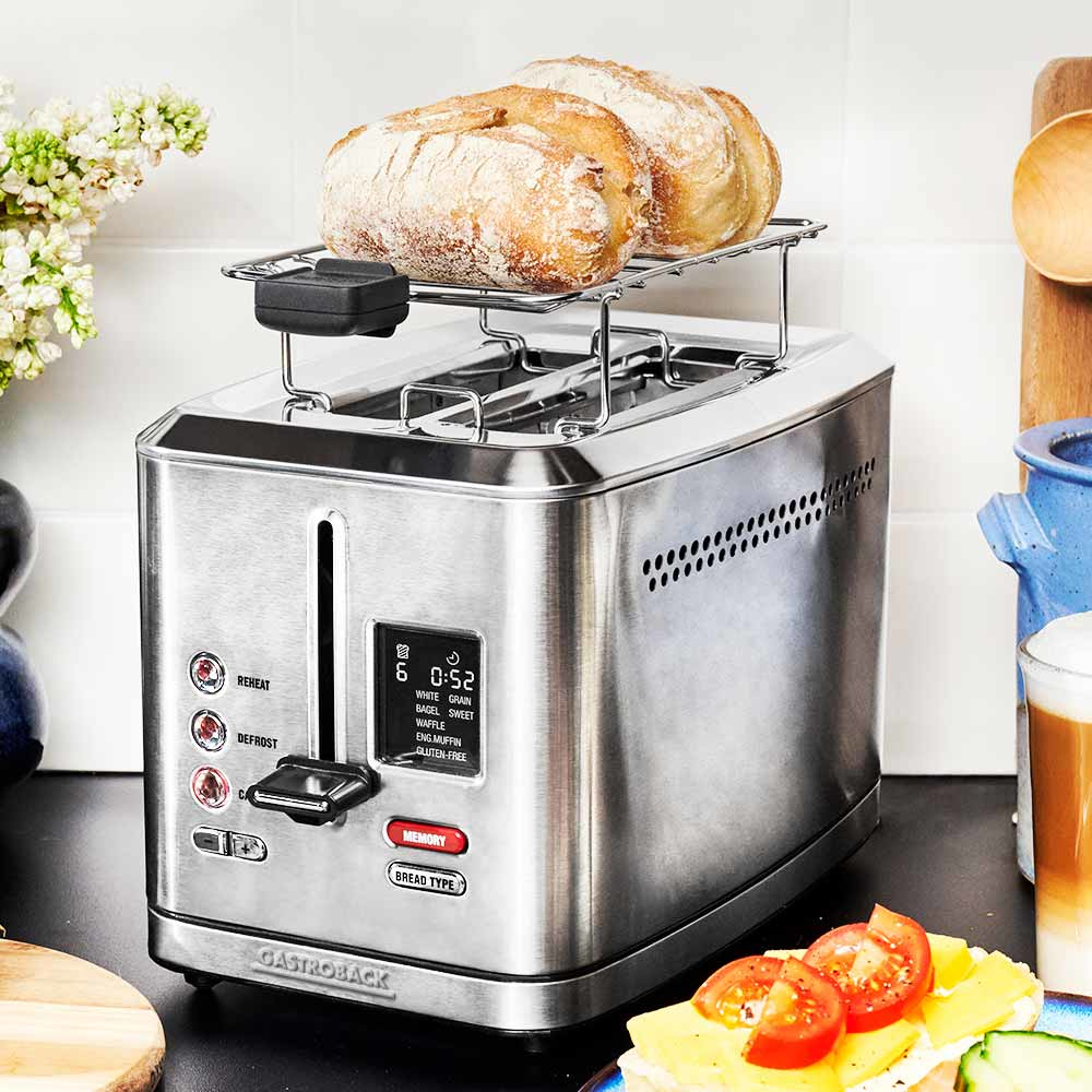 Edelstahl-Toaster mit Brot auf einem Rost. Digitalanzeige, Knöpfe und ein Sandwich darunter.