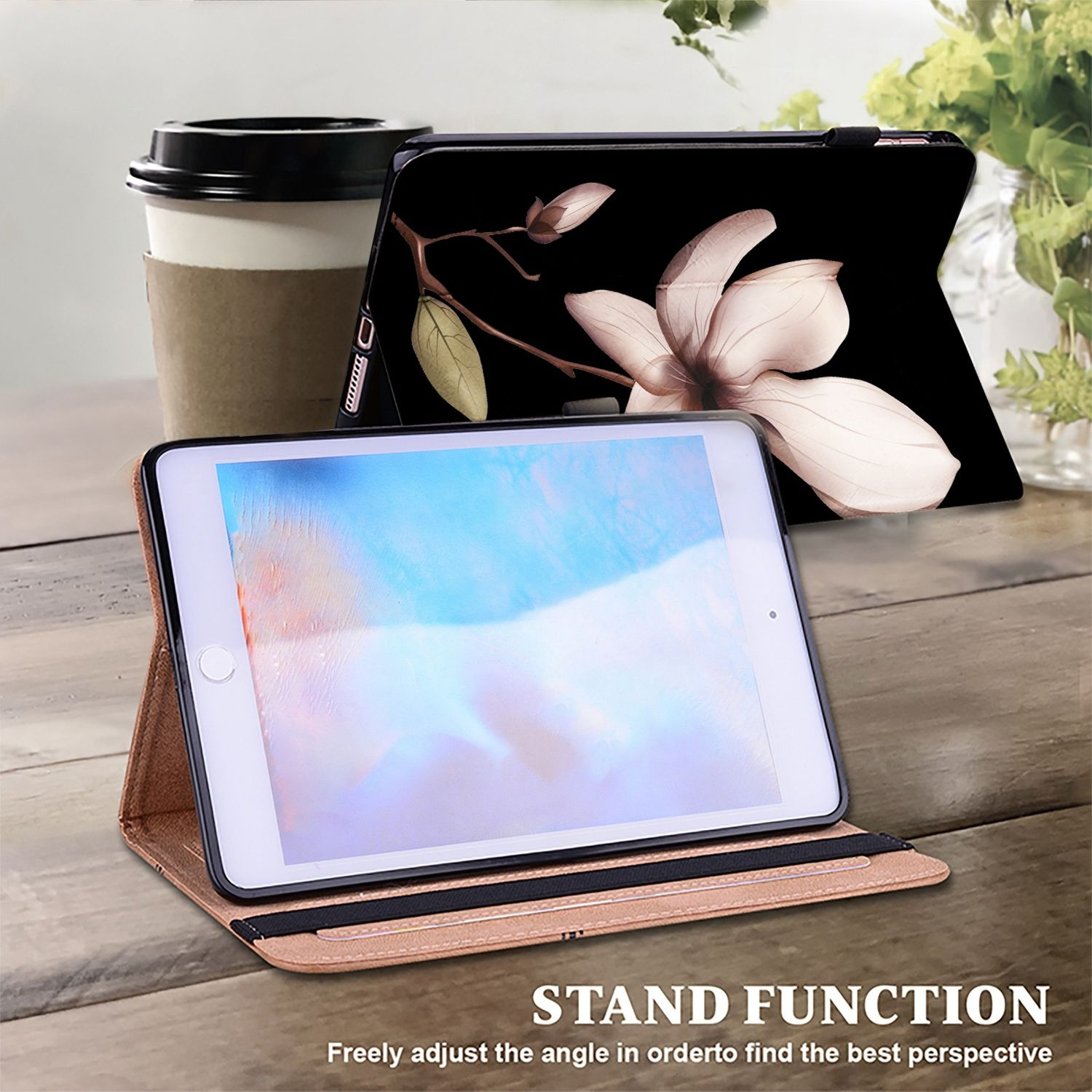 Ein Tablet in einer braunen Hülle. Eine andere Hülle ist im Hintergrund geöffnet. Die Hülle hat ein florales Design. Standfunktion.