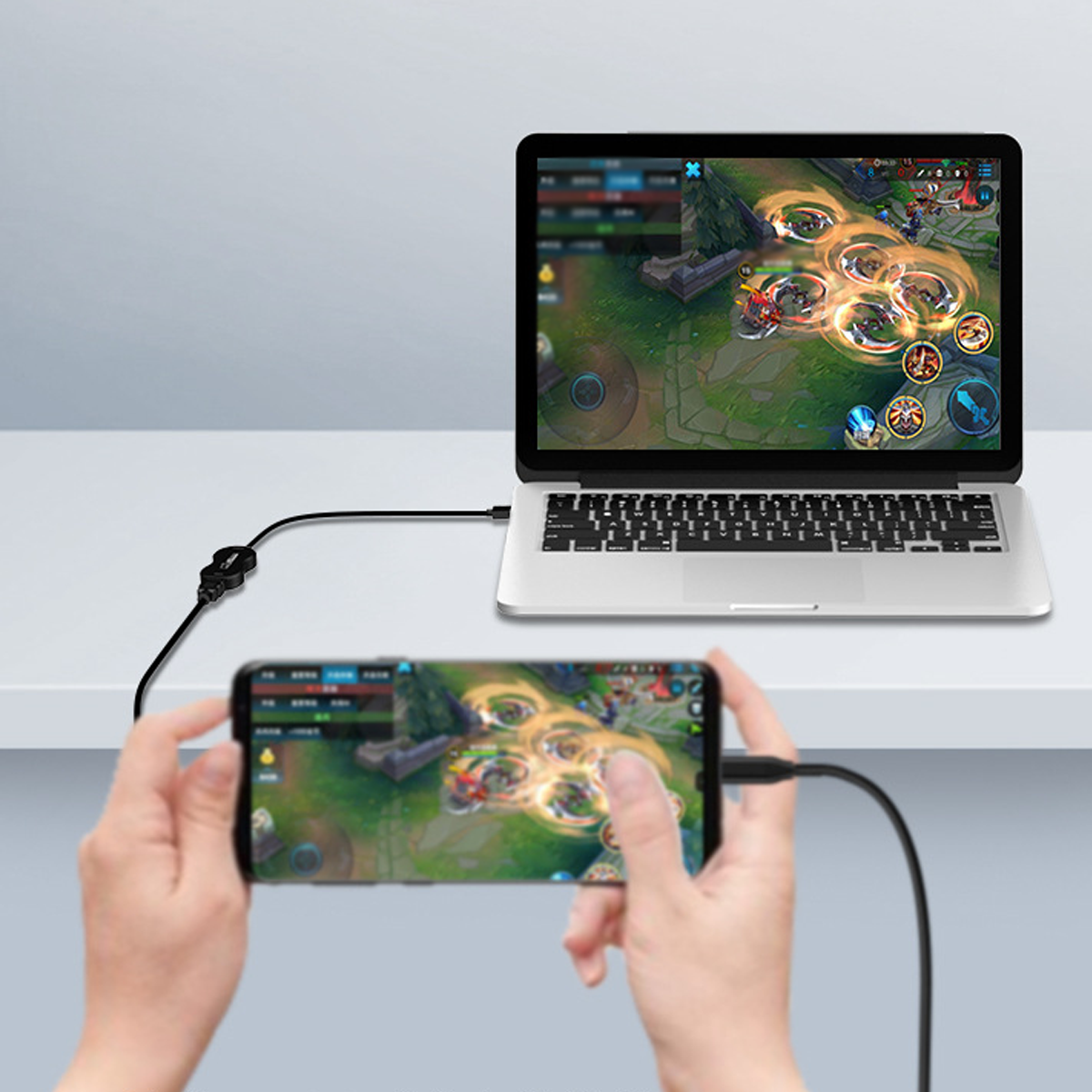 Laptop und Telefon mit Kabel verbunden, zeigen Spiel.
