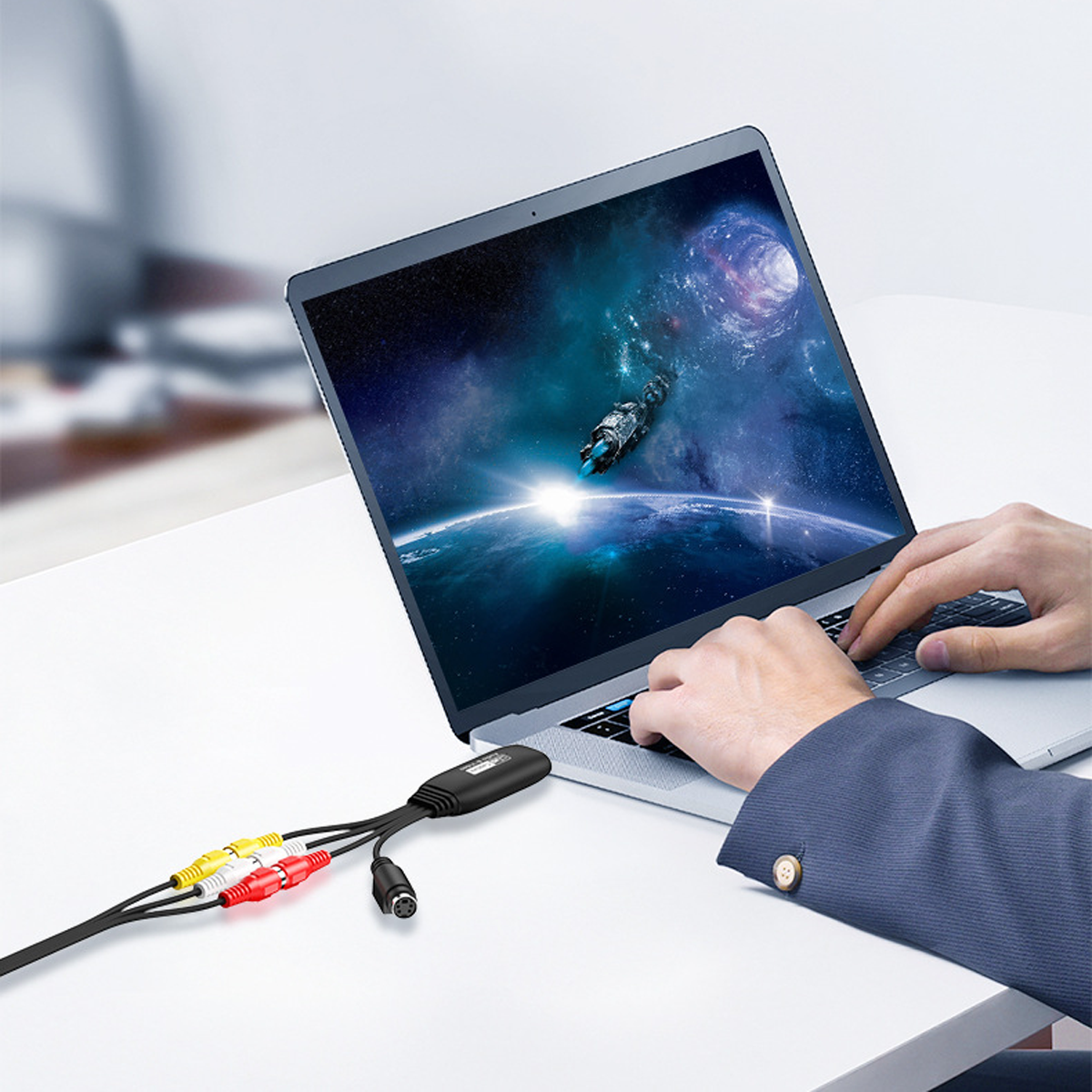 Laptop mit Weltraumszene, verbunden mit AV-Kabeln. Person tippt auf der Tastatur.