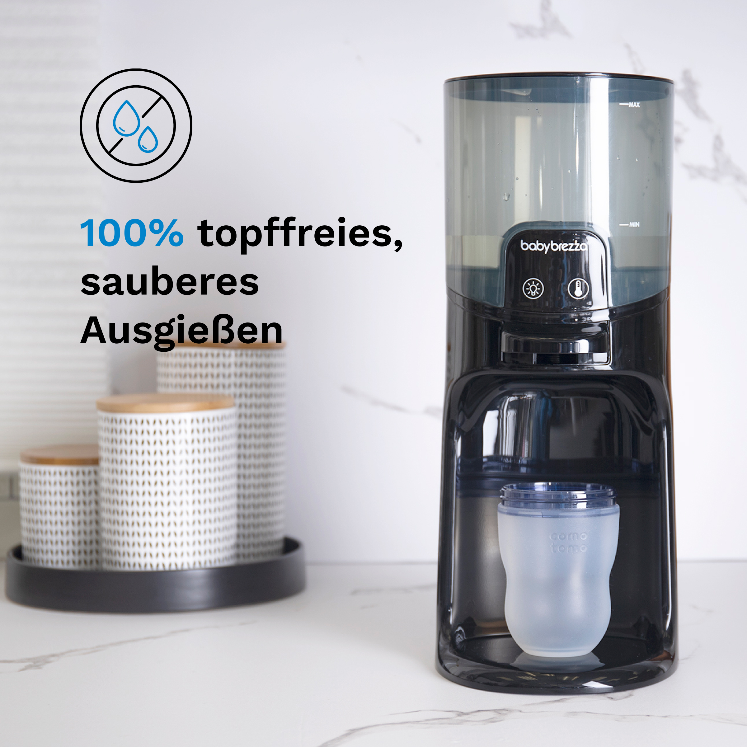 Schwarz-weißer Babyflaschenzubereiter mit klarer Flasche.