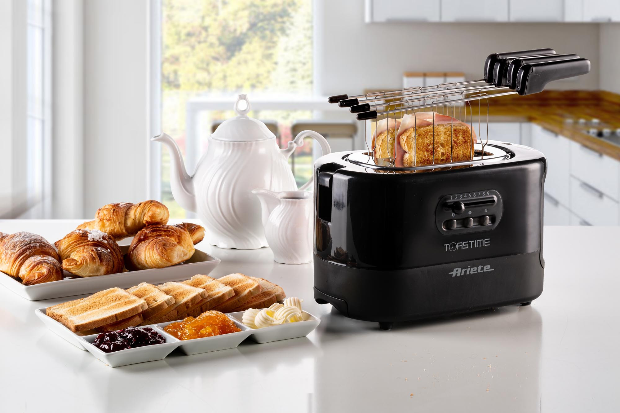 Een ontbijt met toast, croissants, jam en een broodrooster, binnen.