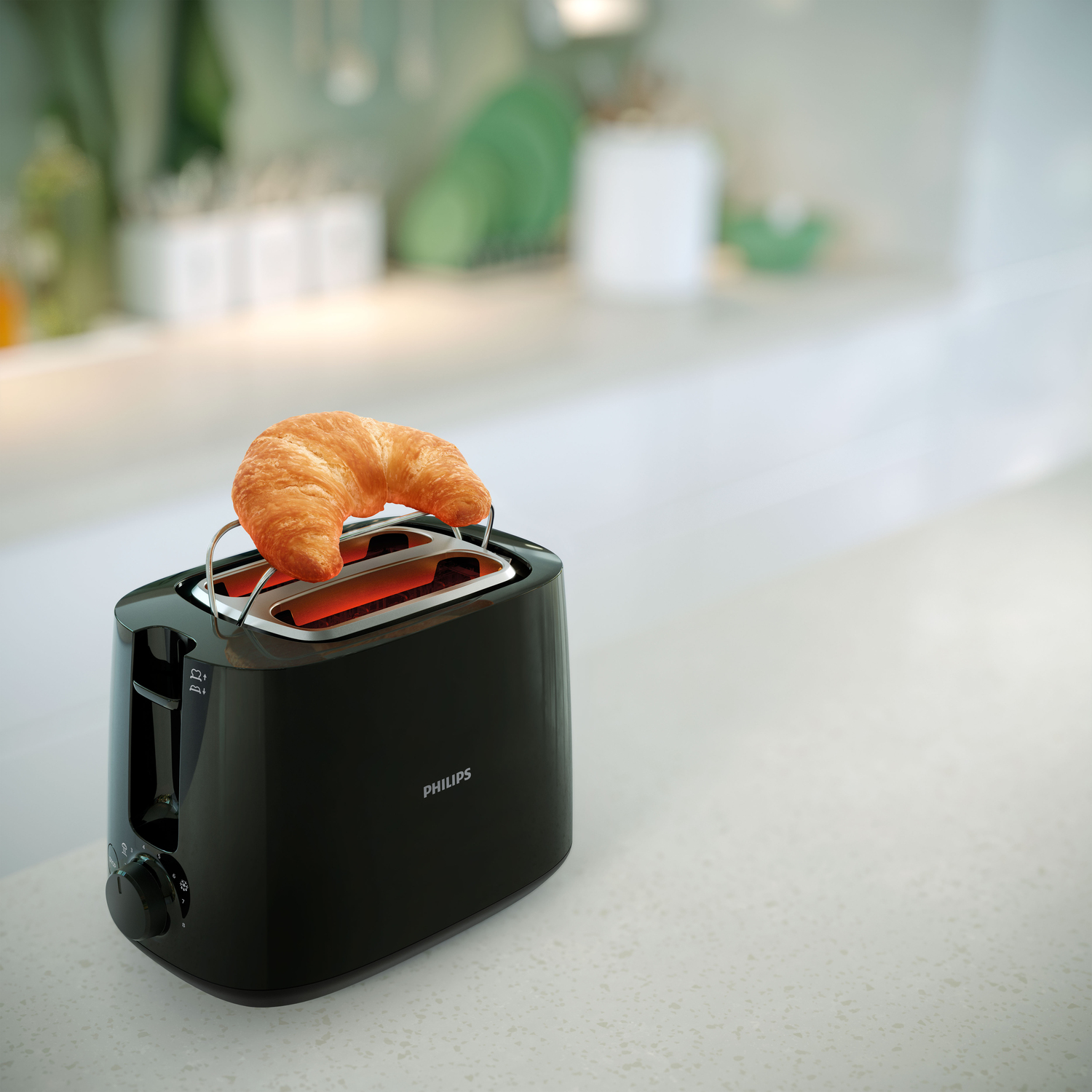 Czarny toster z rogalikiem na górze, gotowy do opiekania, na blacie.