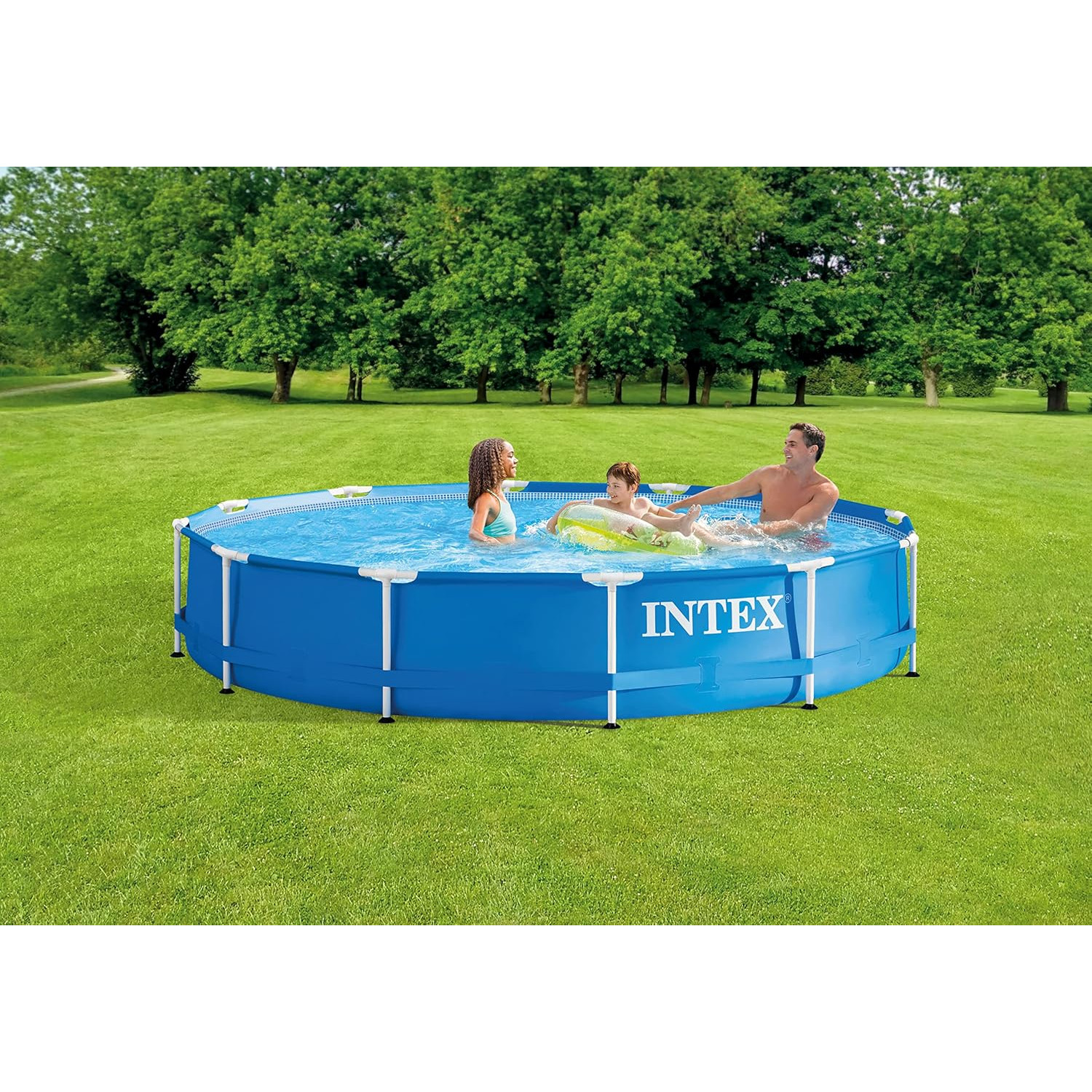 Drei Personen in einem blauen Swimmingpool. Grünes Gras und Bäume im Hintergrund.