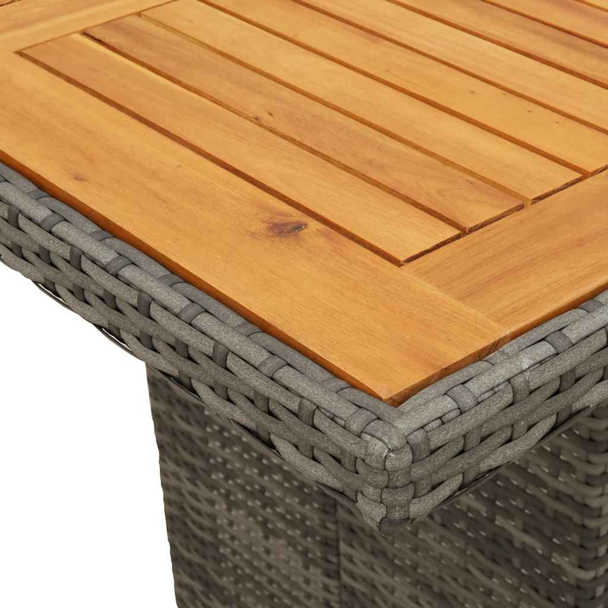 Primo piano di un piano del tavolo in legno. Il tavolo ha un telaio in vimini grigio e una superficie in legno.