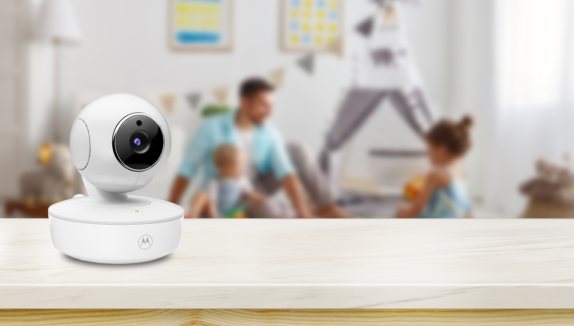 Weiße Babyphone auf Tisch, verschwommener Hintergrund von Familie im Kinderzimmer.