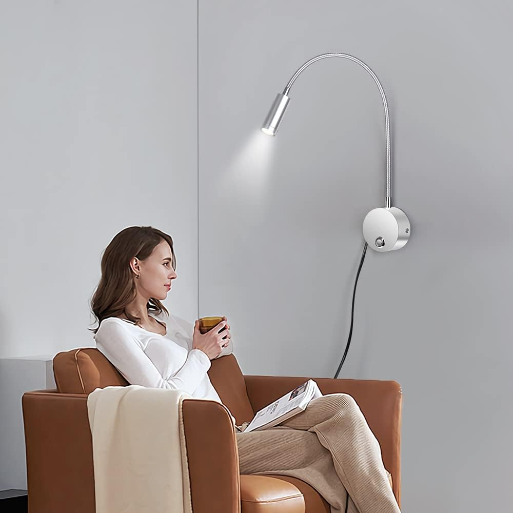 Eine Wand-Leselampe. Das Licht hat einen flexiblen Arm und befindet sich neben einer sitzenden Frau.