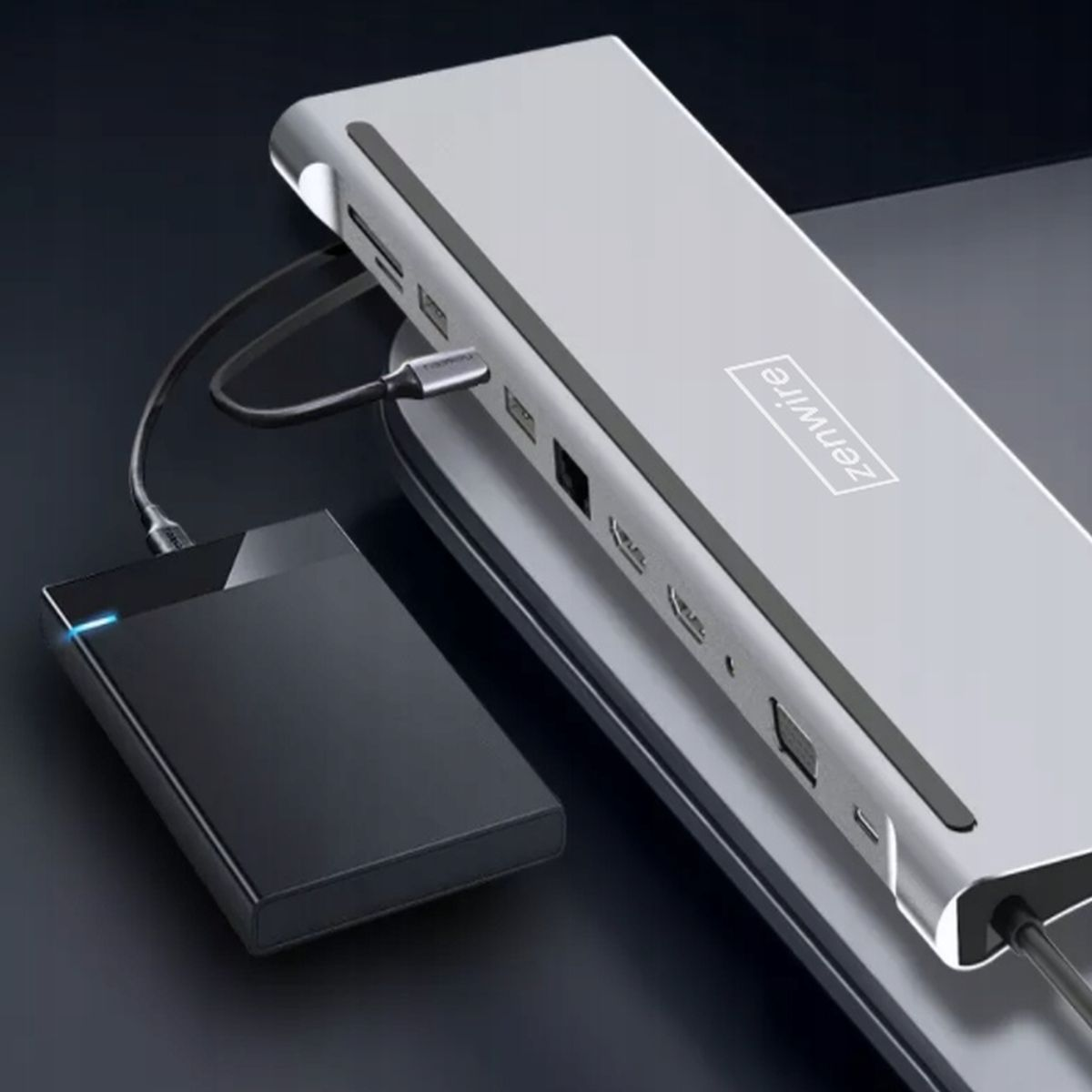 Srebrna stacja dokująca z czarnym dyskiem twardym i podłączonym do niego kablem ładującym.