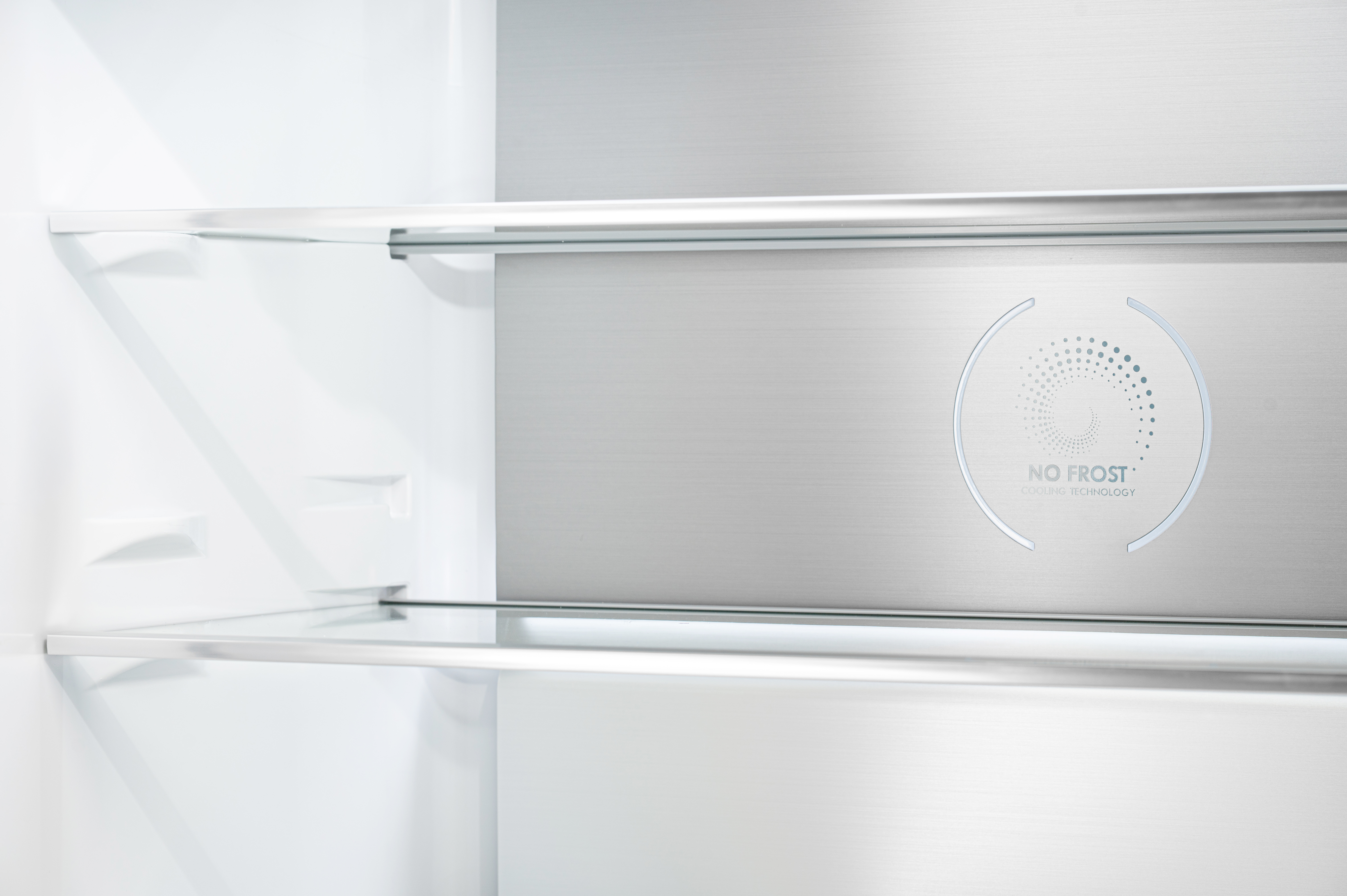 Interno di un frigorifero, mostra ripiani e logo tecnologia 'No Frost'.