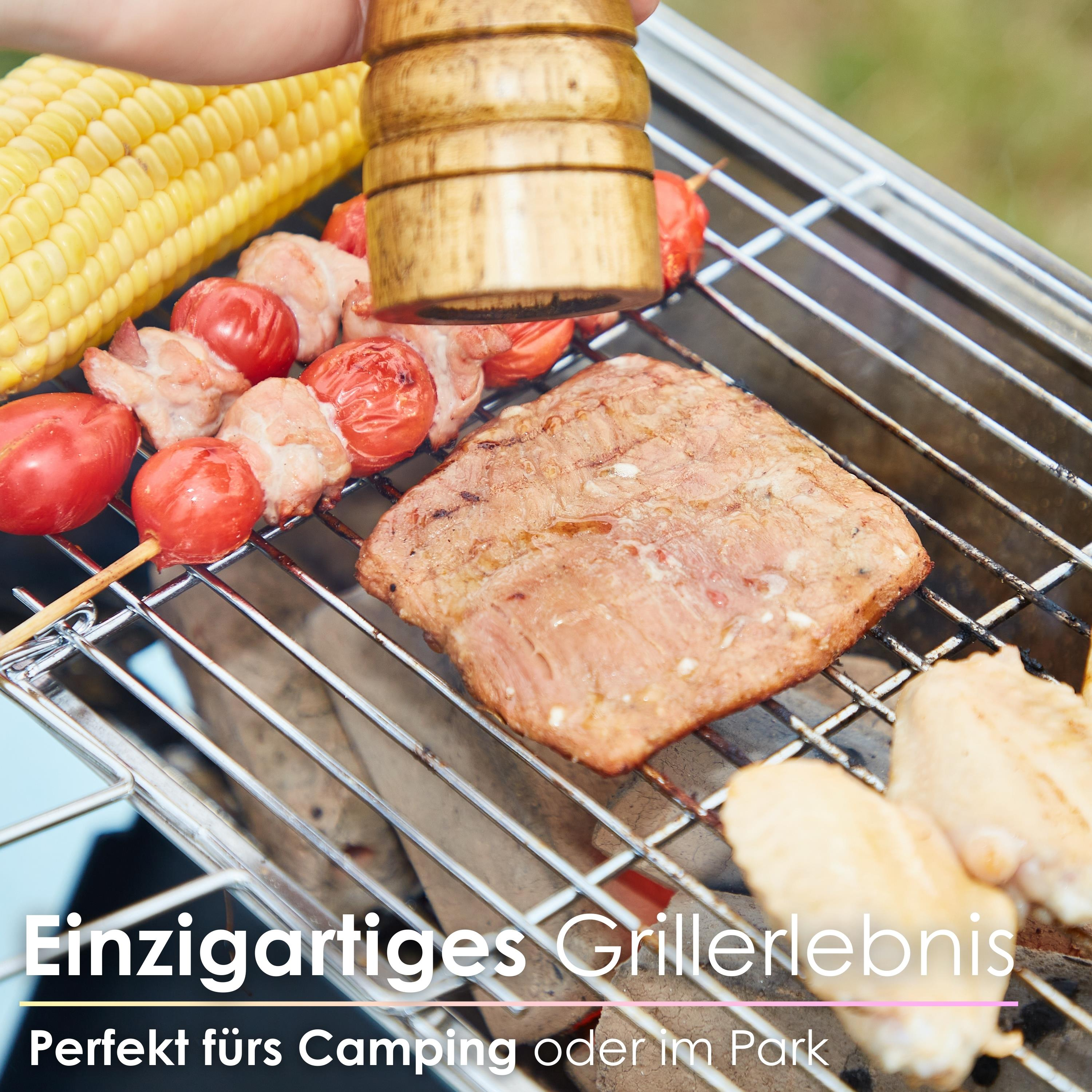 Barbecue mit gegrilltem Fleisch, Gemüse und einer Hand, die einen Holzgriff hält.