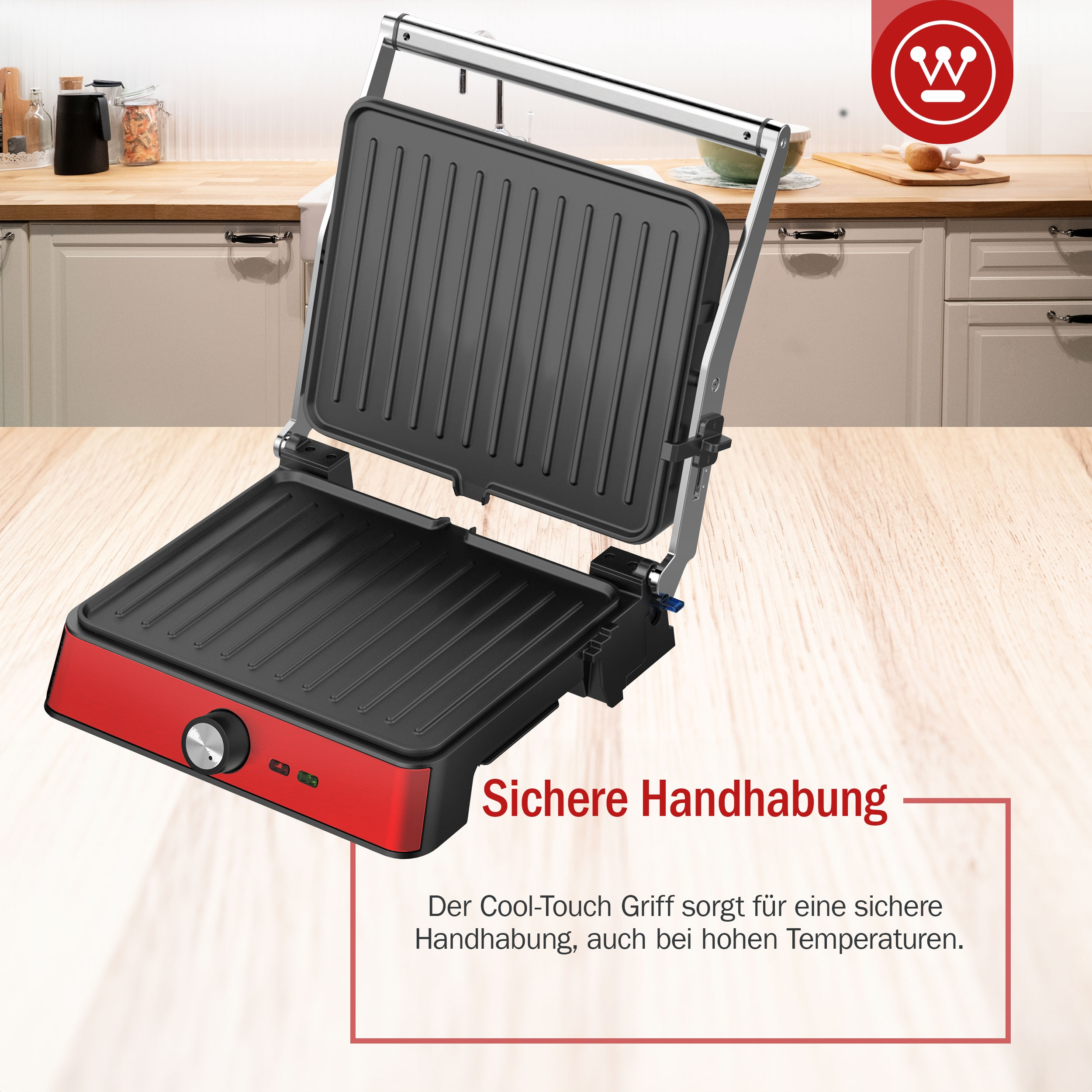 Roter und schwarzer Grill, geöffnet. Rechts sind Küchenschränke zu sehen.