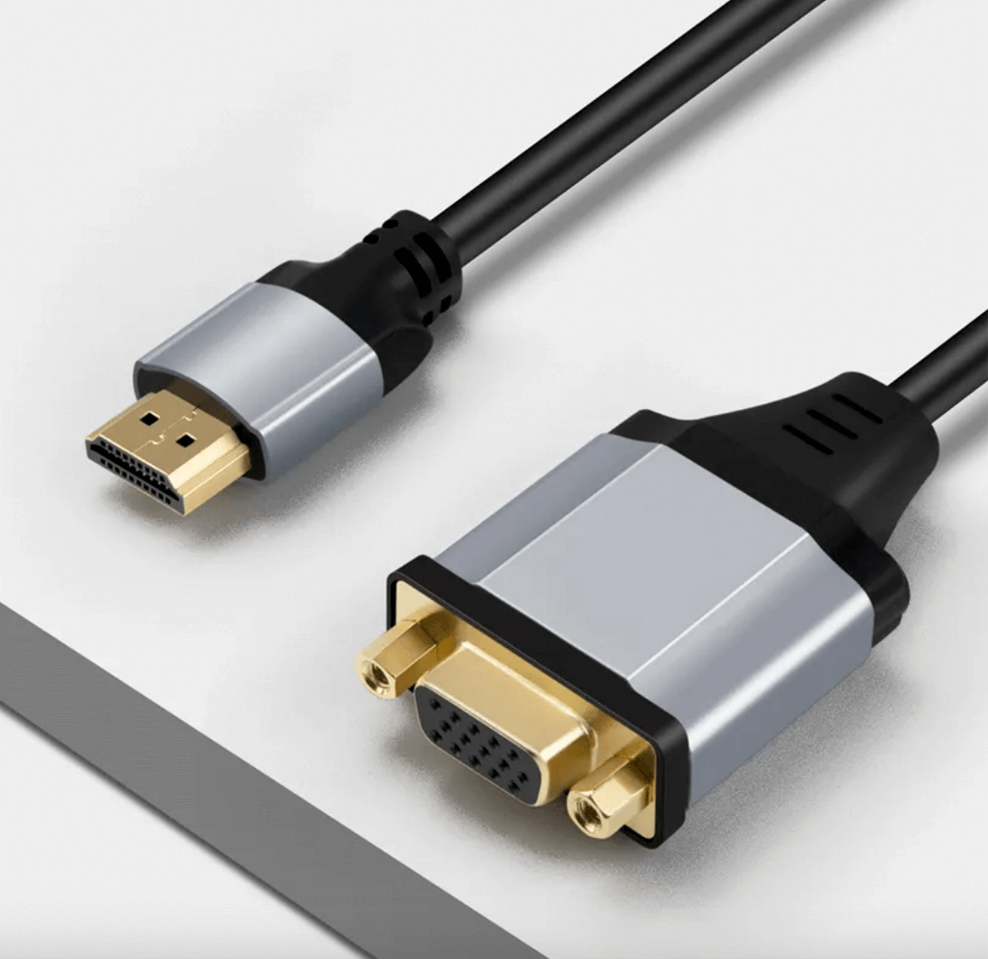 Kable adaptera HDMI do VGA, pozłacane złącza, na białej powierzchni.