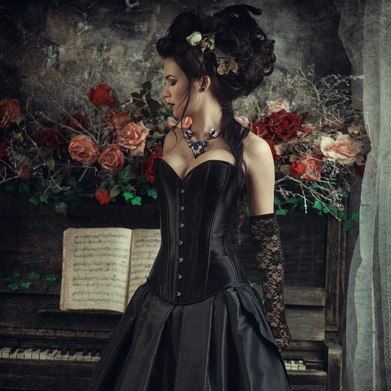 Frau in einem schwarzen Korsett und Kleid steht an einem Klavier mit Blumen und Noten.