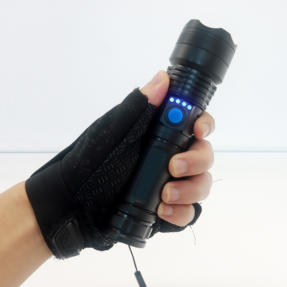 Schwarze Taschenlampe, gehalten von einer Hand mit fingerlosem Handschuh. Blaue Knopflichter.