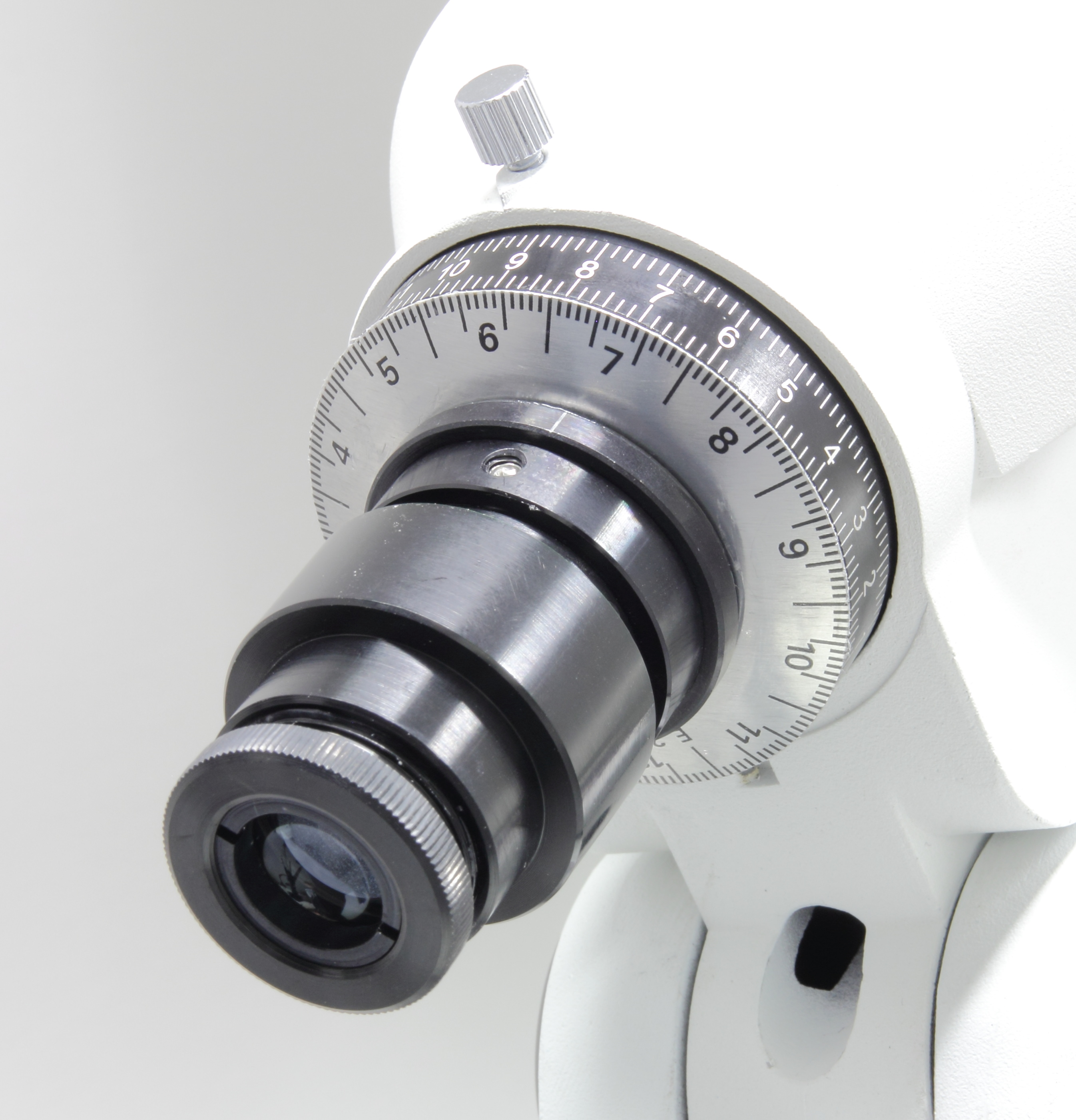 Primer plano del mecanismo de enfoque de un telescopio. Detalles en negro y plata.