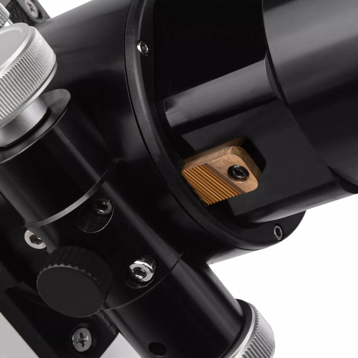 Primer plano de un telescopio negro con lente y varios diales y perillas, sobre un fondo blanco.