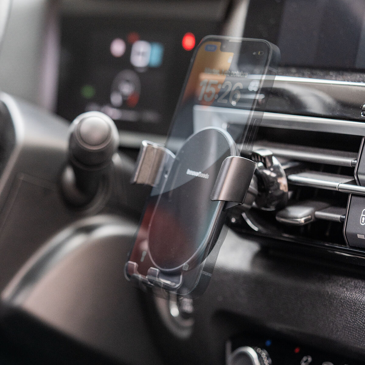 Un telefono in un supporto per auto, montato sul cruscotto.