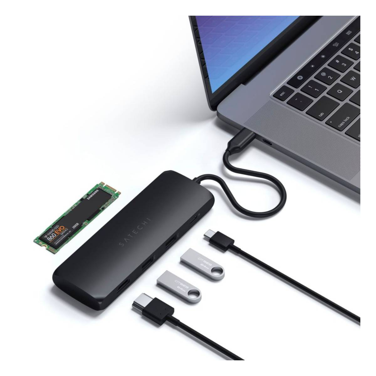 Laptop mit Hub und angeschlossenen Geräten: SSD, USB-Laufwerke und USB-C-Kabel.