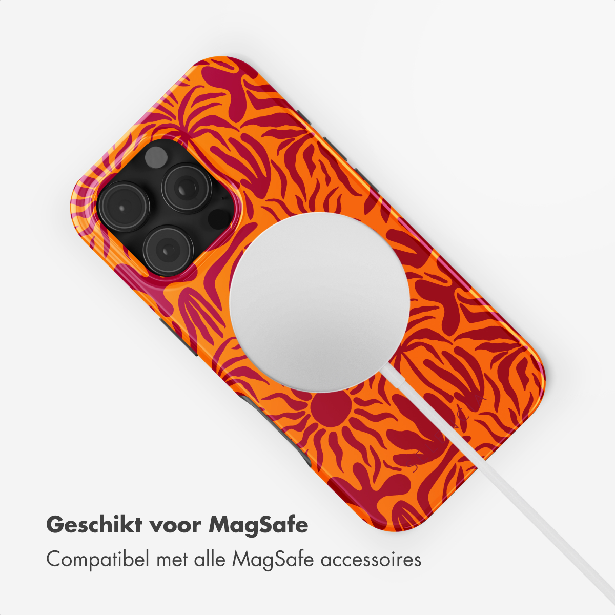 Coque de téléphone orange avec un motif floral rouge, avec un câble de charge blanc.