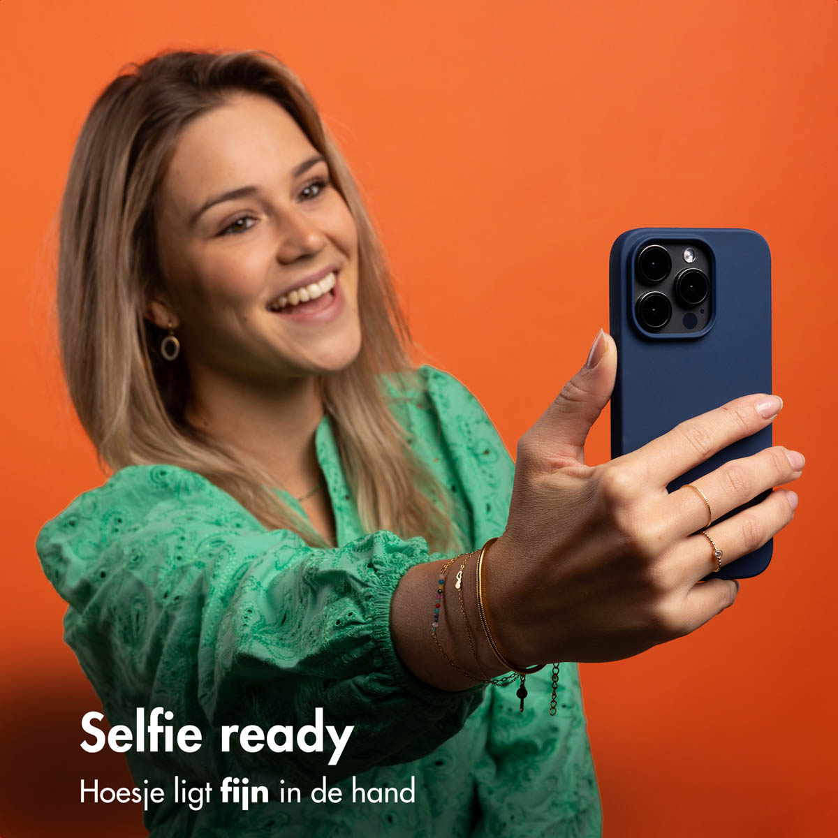 Frau hält ein Telefon, macht ein Selfie. Oranger Hintergrund. Text: Selfie bereit.