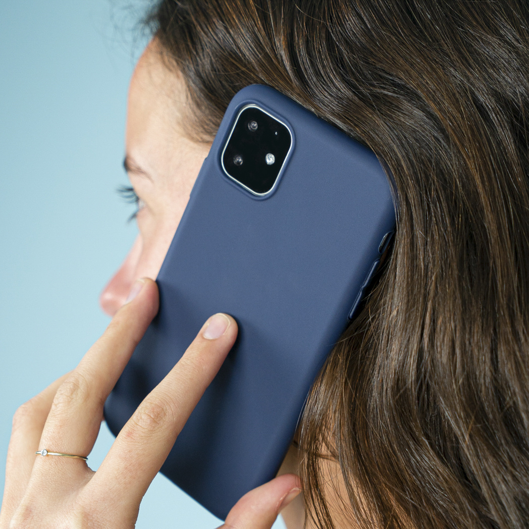 Vrouw die een telefoon met een blauwe hoes gebruikt.